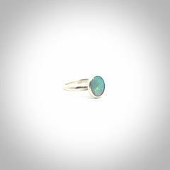 This is a handcrafted real opal ring with sterling silver. The colours are a gorgeous turquoise blue. This is a solid little work of art. We ship this worldwide for free and are happy to answer any questions that you may have about these or other products on our website.