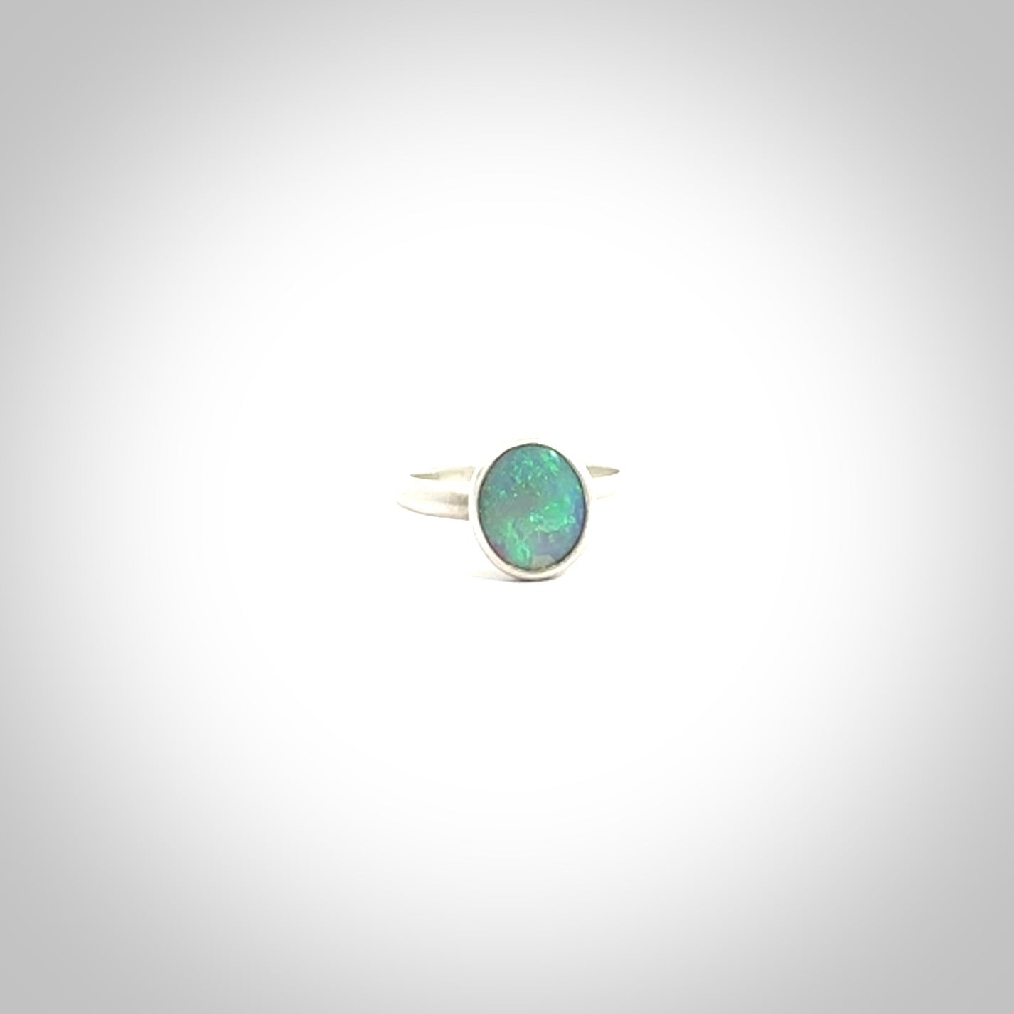 This is a handcrafted real opal ring with sterling silver. The colours are a gorgeous turquoise blue. This is a solid little work of art. We ship this worldwide for free and are happy to answer any questions that you may have about these or other products on our website.