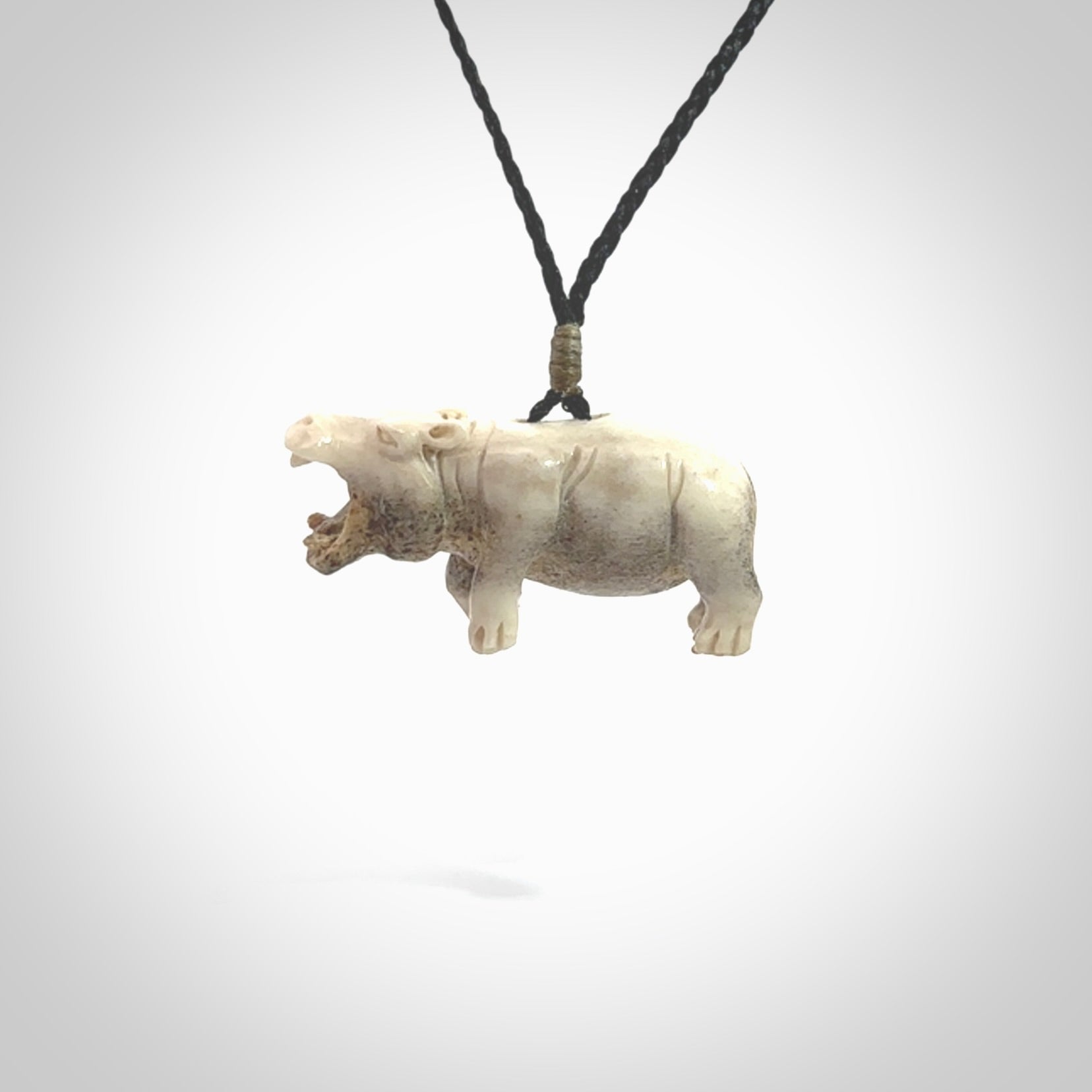 Hand carved deer antler hippo pendant. Hand carved by NZ Pacific. Free postage worldwide. Hand made hippopotamus necklace from deer antler. Animal themed necklace for men and women. Delivered on an adjustable cord in a woven kete pouch.