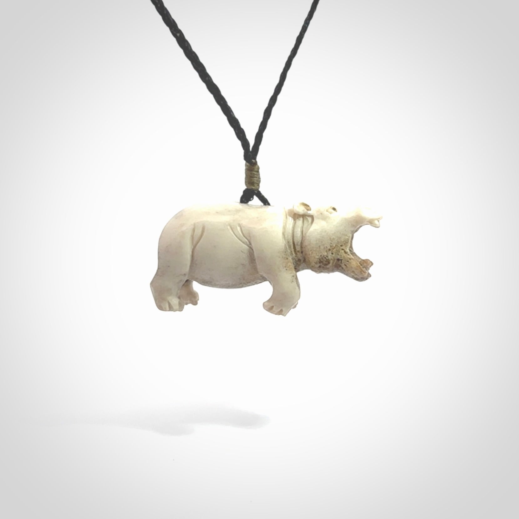 Hand carved deer antler hippo pendant. Hand carved by NZ Pacific. Free postage worldwide. Hand made hippopotamus necklace from deer antler. Animal themed necklace for men and women. Delivered on an adjustable cord in a woven kete pouch.