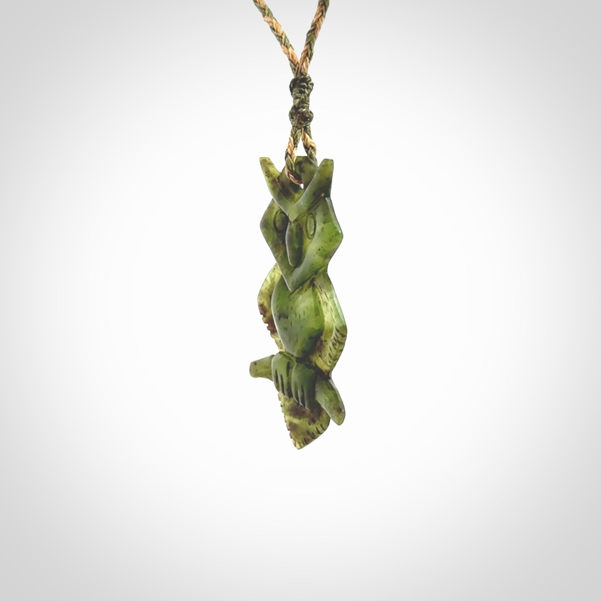 This photo shows a owl pendant carved from New Zealand Totoweka Jade. The artist, Shaun Gardiner, has carved this beautifully. We provide this piece with an adjustable green/tan cord. This is a fantastic work of art, we have one only.