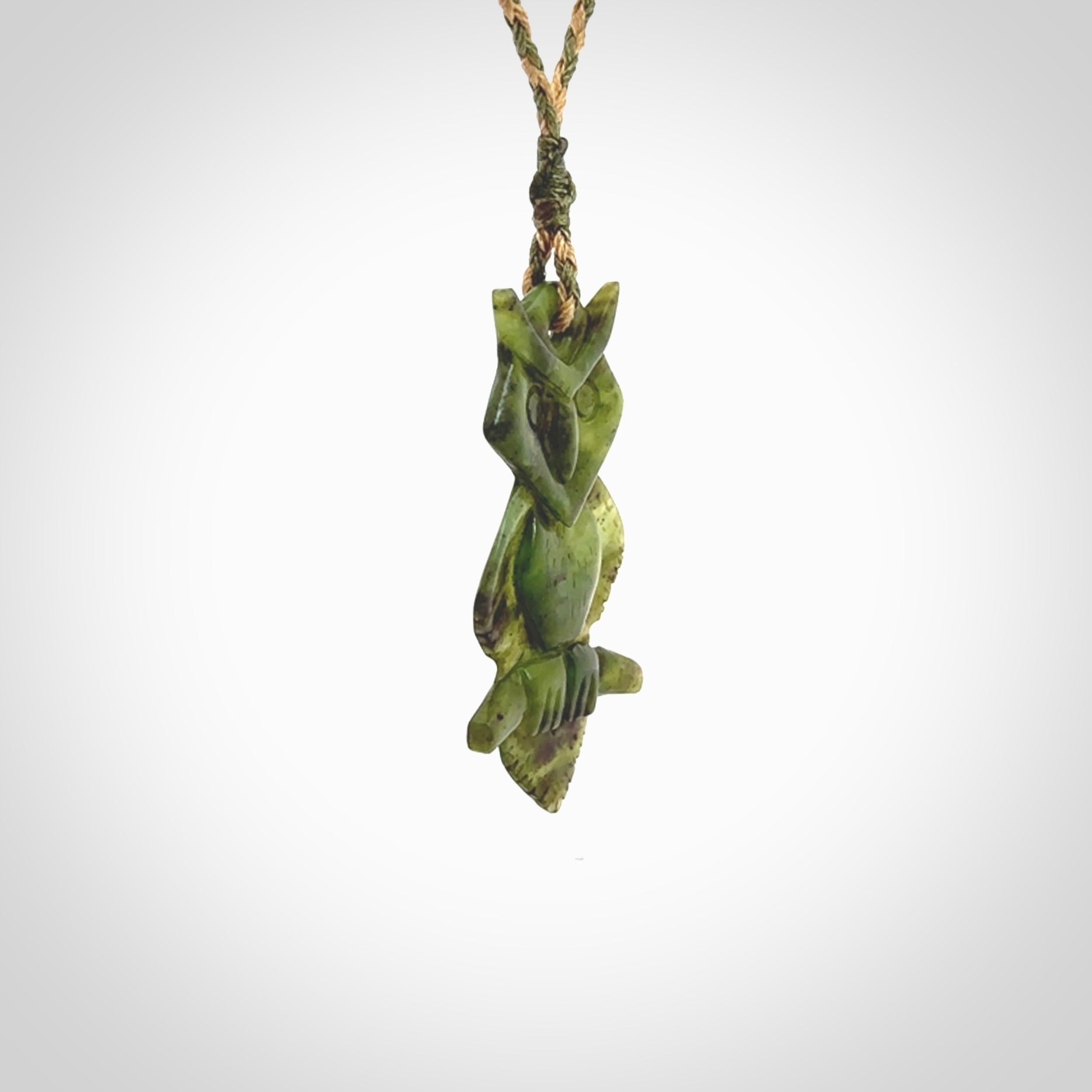 This photo shows a owl pendant carved from New Zealand Totoweka Jade. The artist, Shaun Gardiner, has carved this beautifully. We provide this piece with an adjustable green/tan cord. This is a fantastic work of art, we have one only.