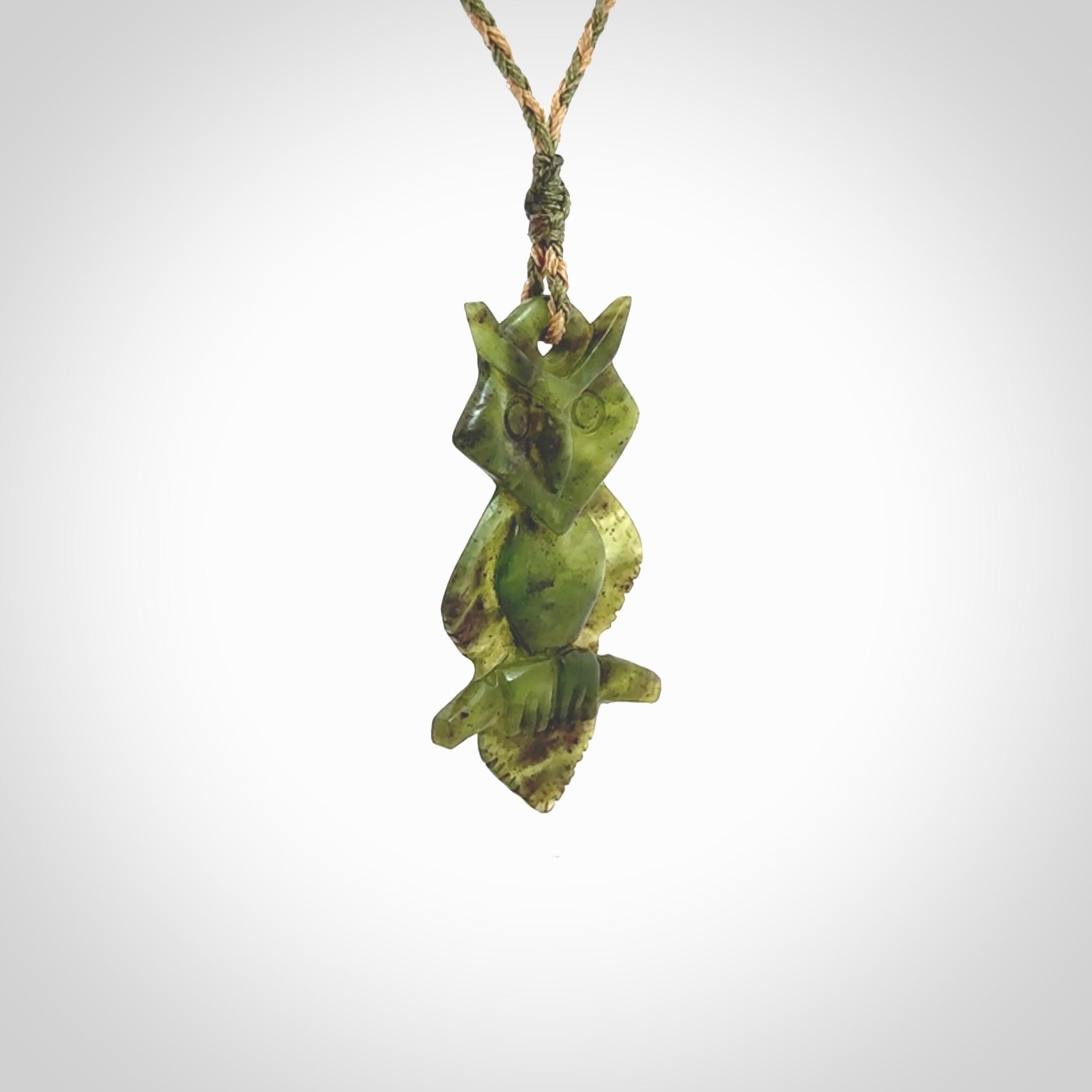 This photo shows a owl pendant carved from New Zealand Totoweka Jade. The artist, Shaun Gardiner, has carved this beautifully. We provide this piece with an adjustable green/tan cord. This is a fantastic work of art, we have one only.