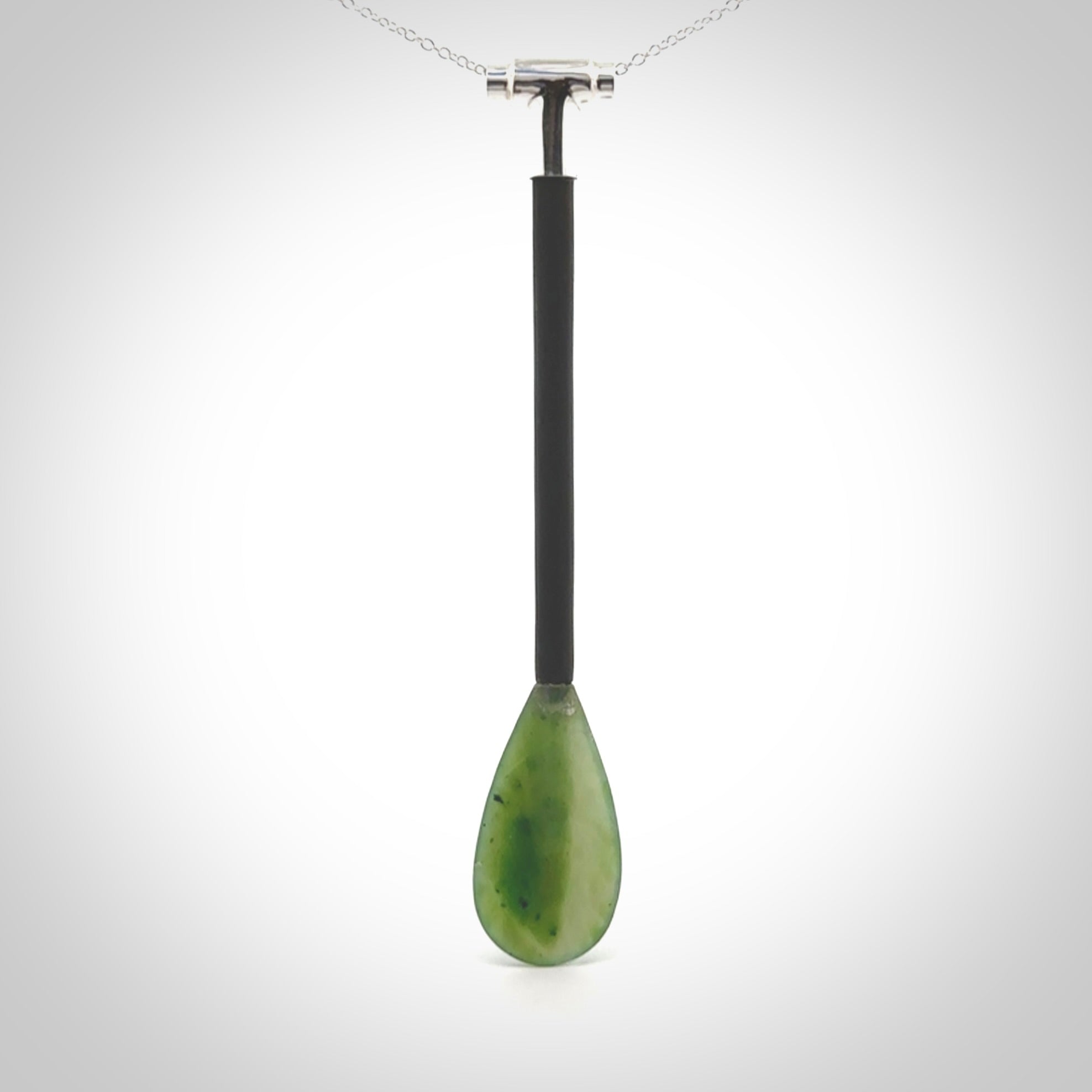 This pendant is a hand carved boat paddle. We have carved this with a Black jade blade or a green jade blade with a hardwood and sterling silver handle. Provided with a sterling silver chain.