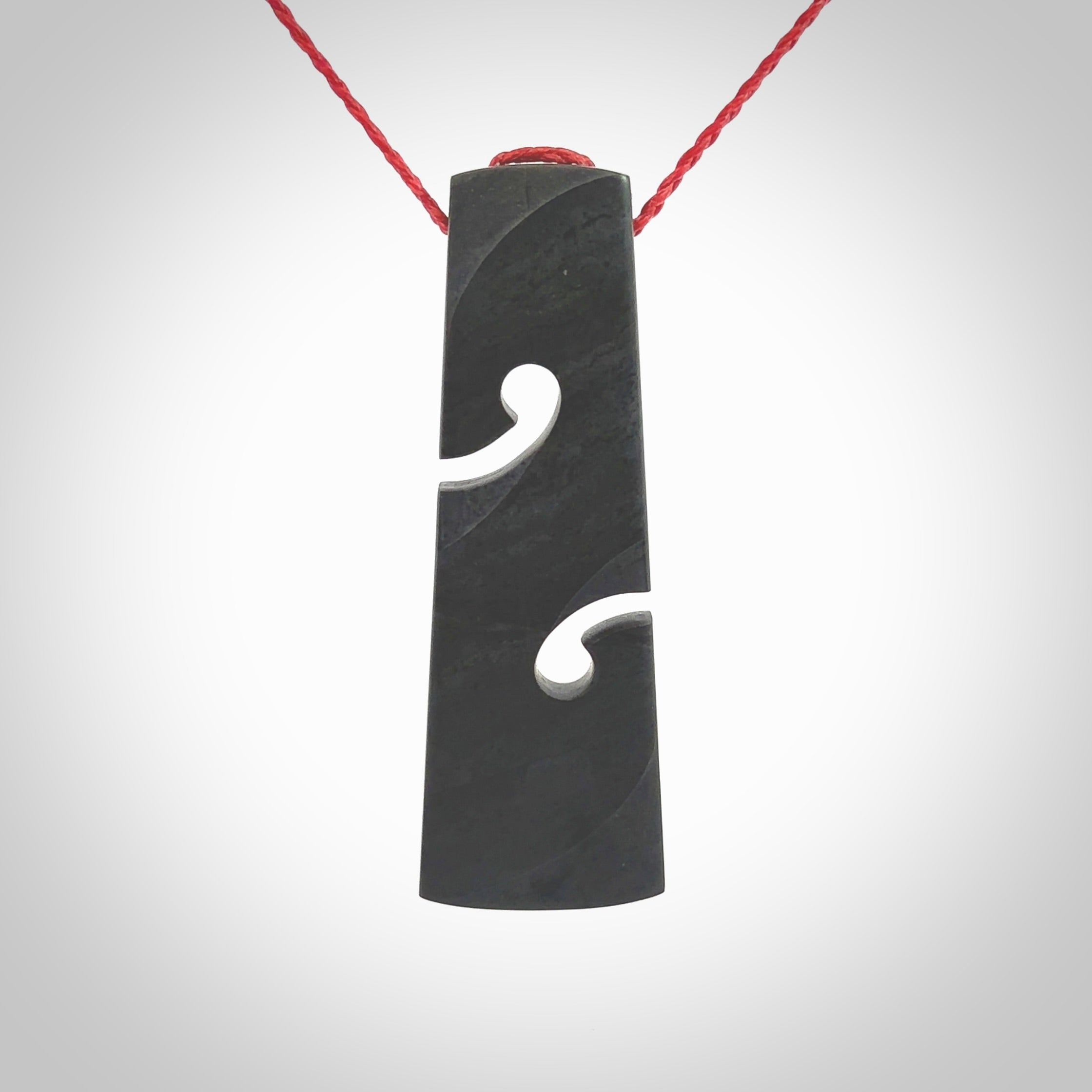 Hand carved New Zealand Argillite Toki with double koru by Rueben Tipene. We provide this large toki on an adjustable cord and ship to you in a kete pouch with Express Courier. This is a one off pendant that once sold will be removed from our site.