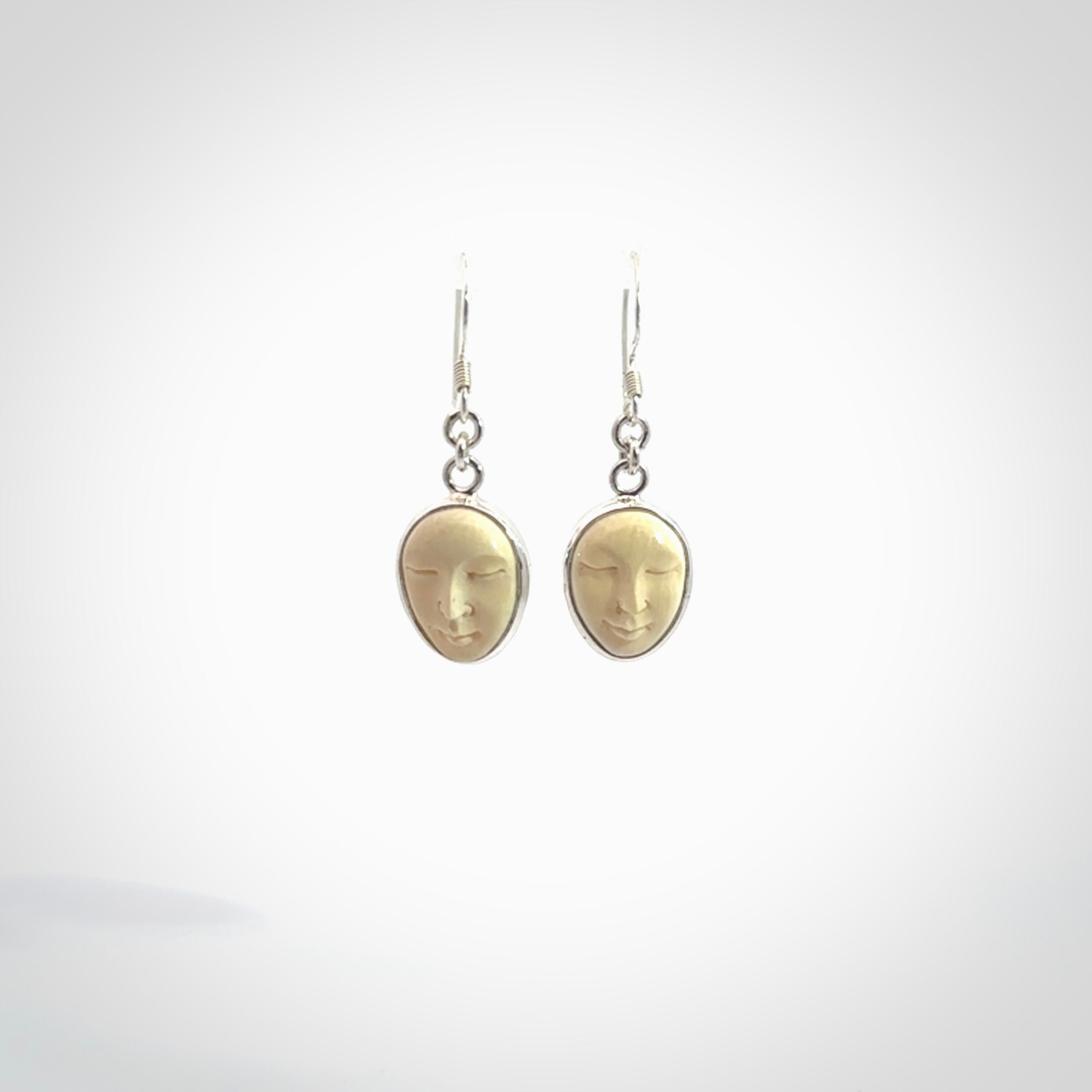 Hand made woolly mammoth tusk moon face earrings. Made by NZ Pacific and sale online only.