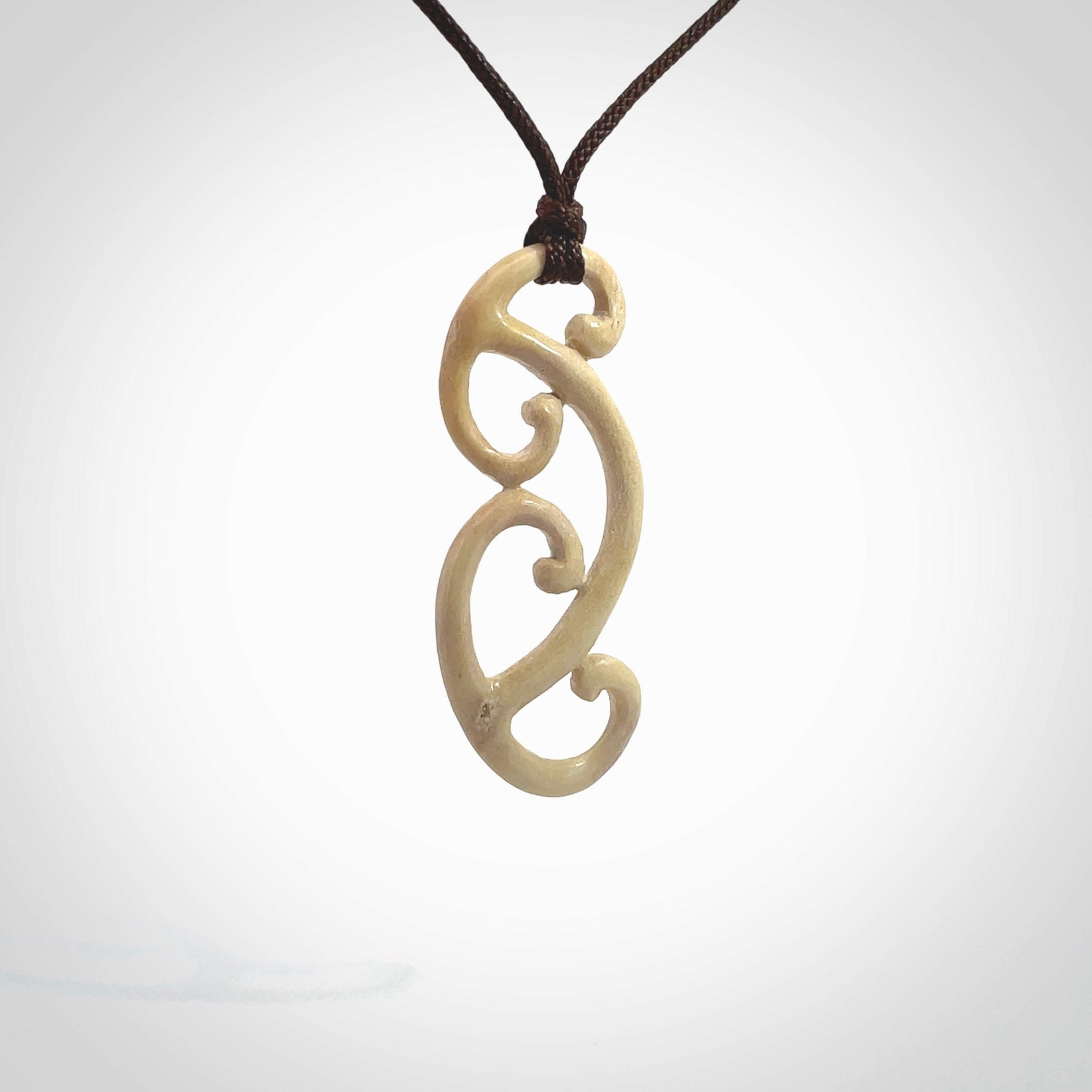 This is a wonderful, gently curved piece with a multiple koru design. We've carved this from deer antler and bind it on adjustable cords of various colours. Order yours now on NZ Pacific at www.nzpacific.com