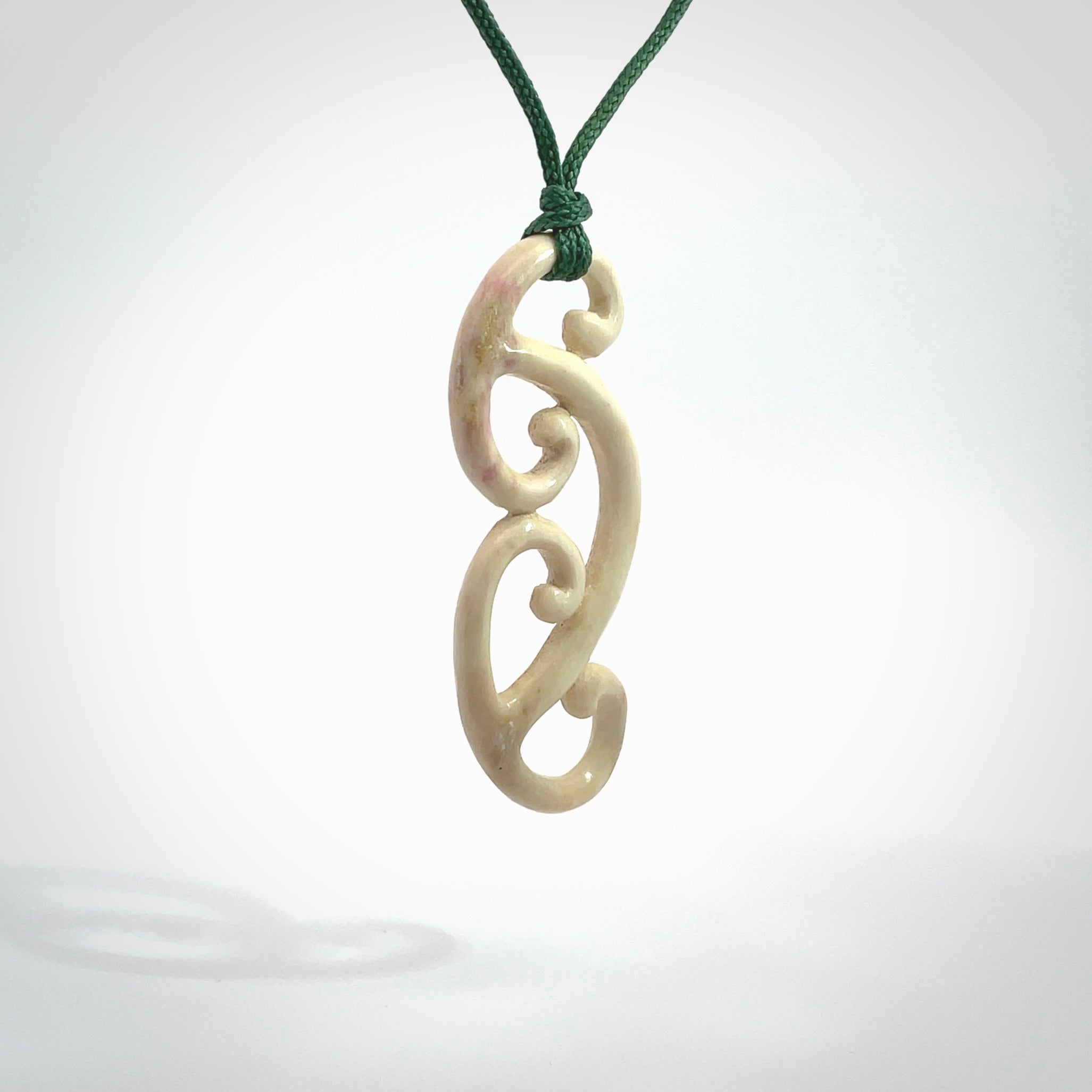 This is a wonderful, gently curved piece with a multiple koru design. We've carved this from deer antler and bind it on adjustable cords of various colours. Order yours now on NZ Pacific at www.nzpacific.com