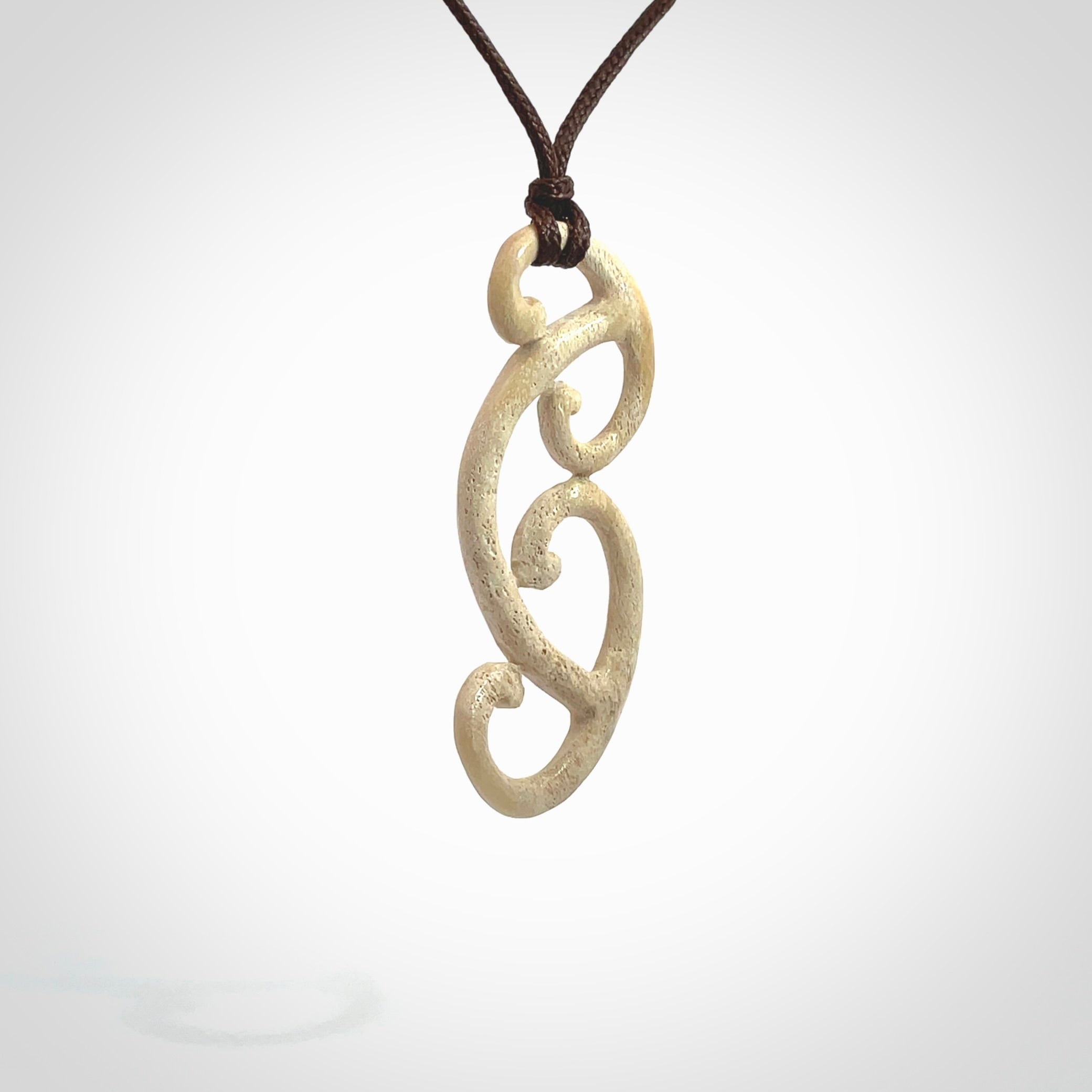 This is a wonderful, gently curved piece with a multiple koru design. We've carved this from deer antler and bind it on adjustable cords of various colours. Order yours now on NZ Pacific at www.nzpacific.com