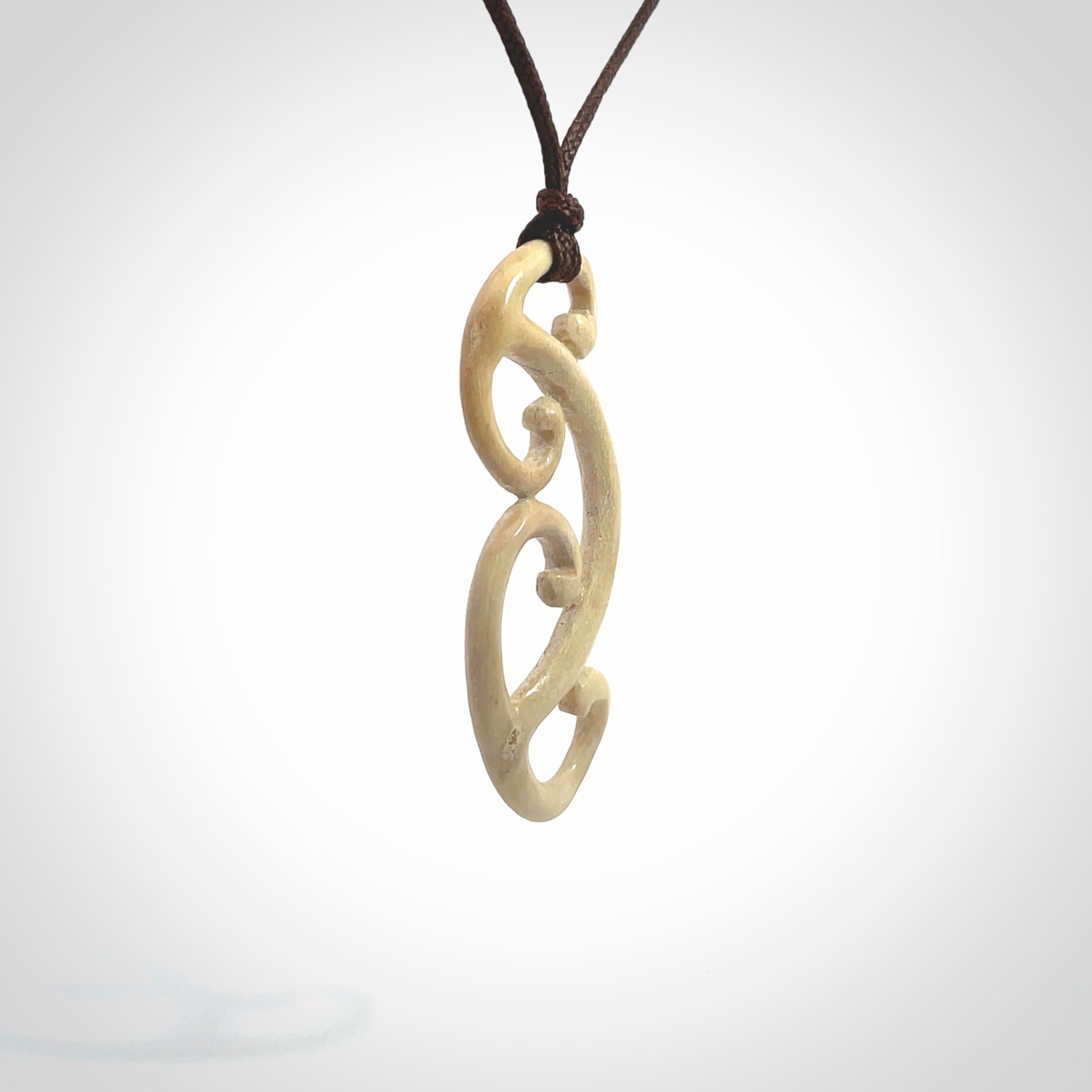 This is a wonderful, gently curved piece with a multiple koru design. We've carved this from deer antler and bind it on adjustable cords of various colours. Order yours now on NZ Pacific at www.nzpacific.com