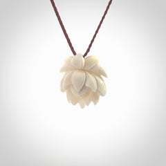 This is a hand carved lotus flower pendant. It is made from bone. This is a medium sized necklace and is a very unique pendant and is a wonderful necklace to wear. Hand carved bone lotus flower pendant with adjustable cord.