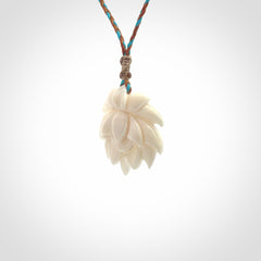 This is a hand carved lotus flower pendant. It is made from bone. This is a medium sized necklace and is a very unique pendant and is a wonderful necklace to wear. Hand carved bone lotus flower pendant with adjustable cord.