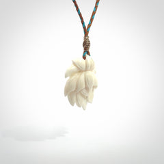 This is a hand carved lotus flower pendant. It is made from bone. This is a medium sized necklace and is a very unique pendant and is a wonderful necklace to wear. Hand carved bone lotus flower pendant with adjustable cord.