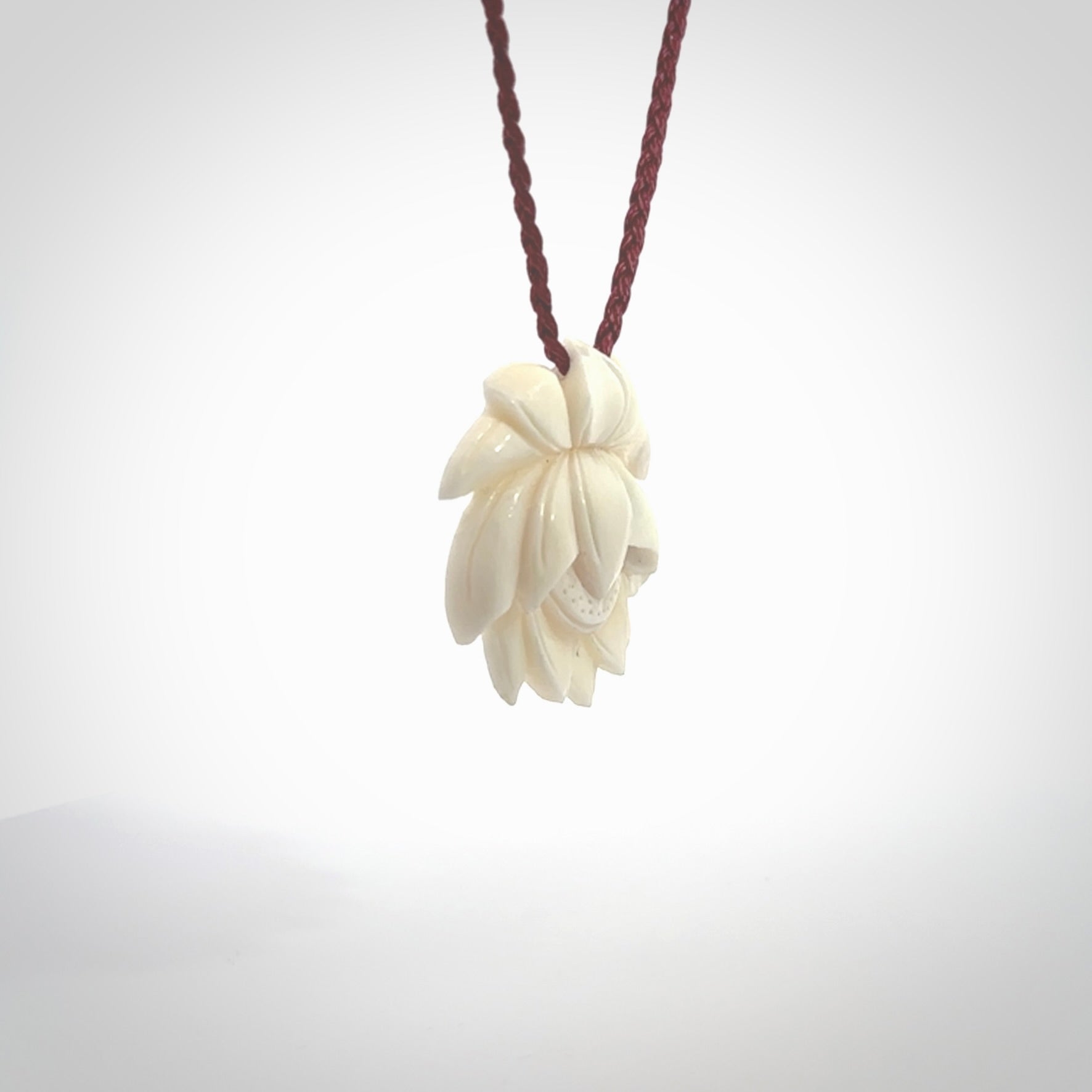 This is a hand carved lotus flower pendant. It is made from bone. This is a medium sized necklace and is a very unique pendant and is a wonderful necklace to wear. Hand carved bone lotus flower pendant with adjustable cord.