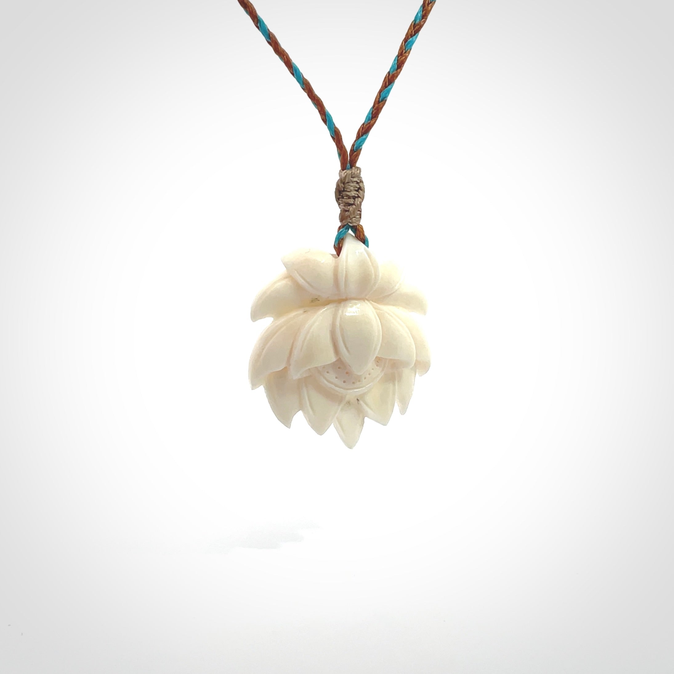 This is a hand carved lotus flower pendant. It is made from bone. This is a medium sized necklace and is a very unique pendant and is a wonderful necklace to wear. Hand carved bone lotus flower pendant with adjustable cord.