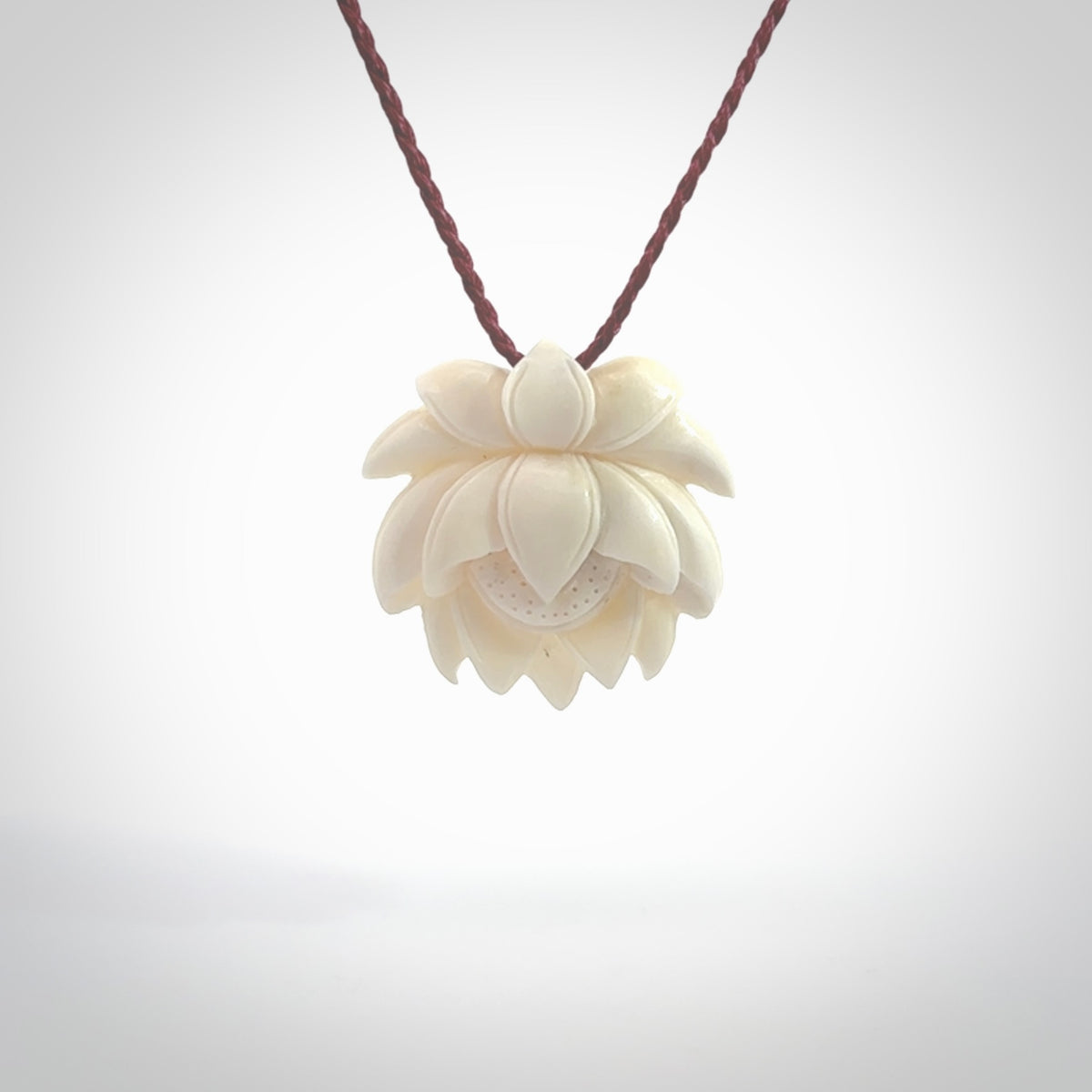 This is a hand carved lotus flower pendant. It is made from bone. This is a medium sized necklace and is a very unique pendant and is a wonderful necklace to wear. Hand carved bone lotus flower pendant with adjustable cord.