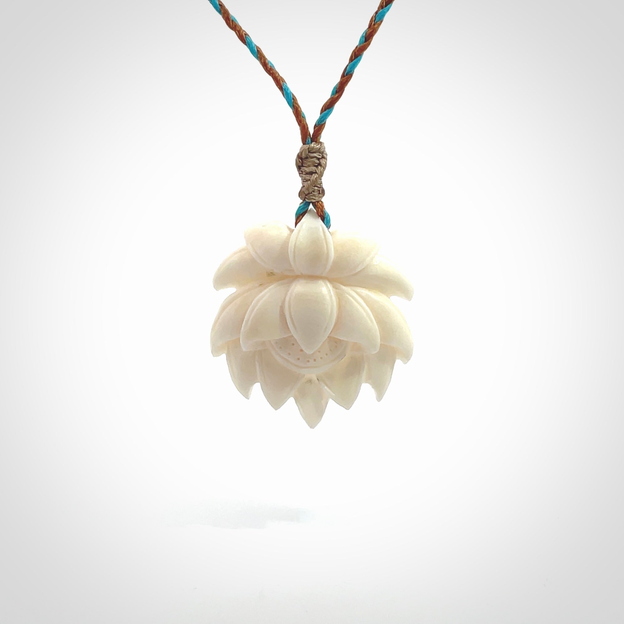 This is a hand carved lotus flower pendant. It is made from bone. This is a medium sized necklace and is a very unique pendant and is a wonderful necklace to wear. Hand carved bone lotus flower pendant with adjustable cord.