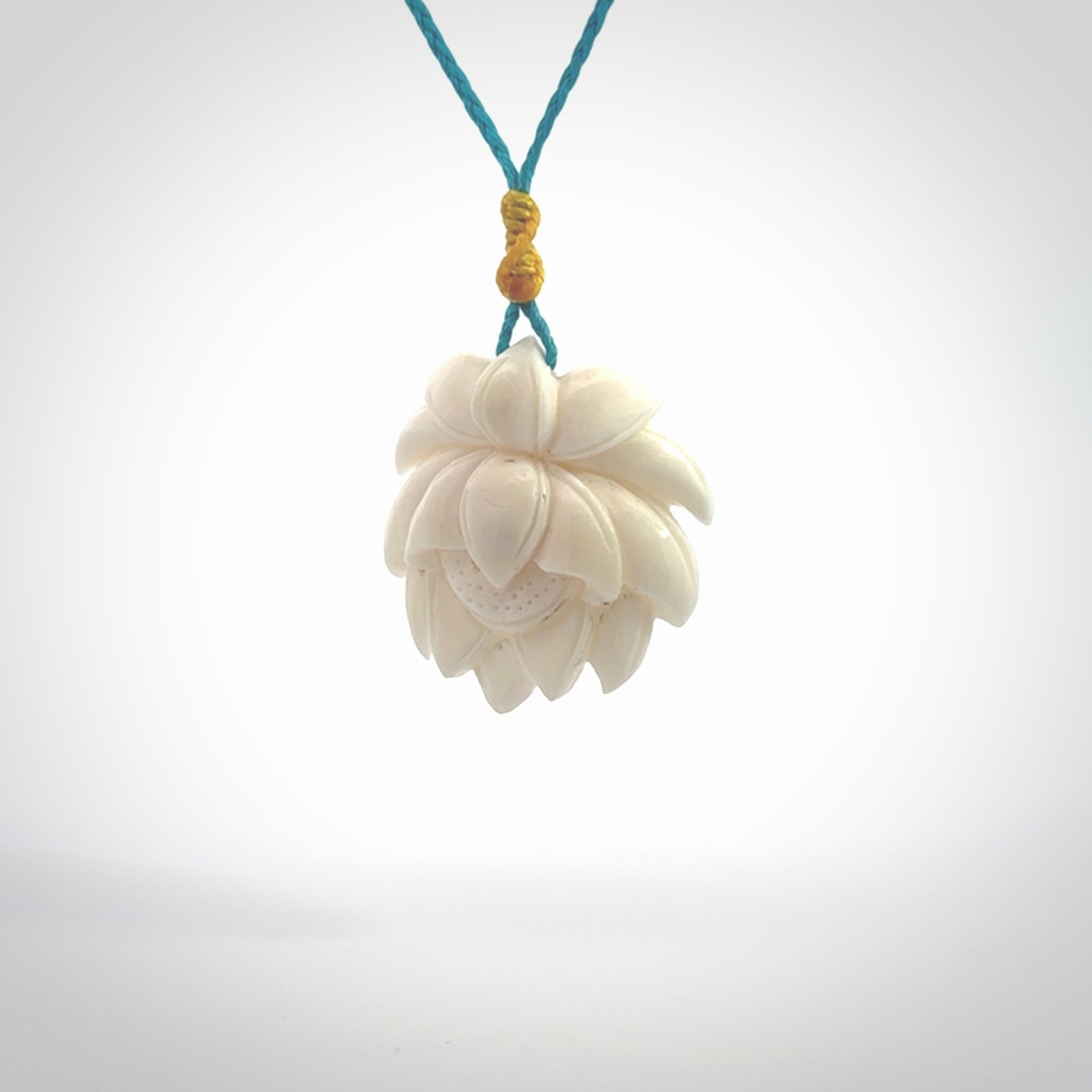 This is a hand carved lotus flower pendant. It is made from bone. This is a medium sized necklace and is a very unique pendant and is a wonderful necklace to wear. Hand carved bone lotus flower pendant with adjustable cord.