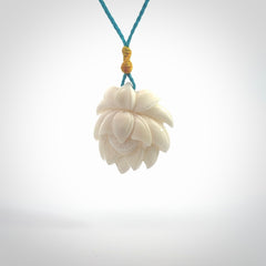 This is a hand carved lotus flower pendant. It is made from bone. This is a medium sized necklace and is a very unique pendant and is a wonderful necklace to wear. Hand carved bone lotus flower pendant with adjustable cord.