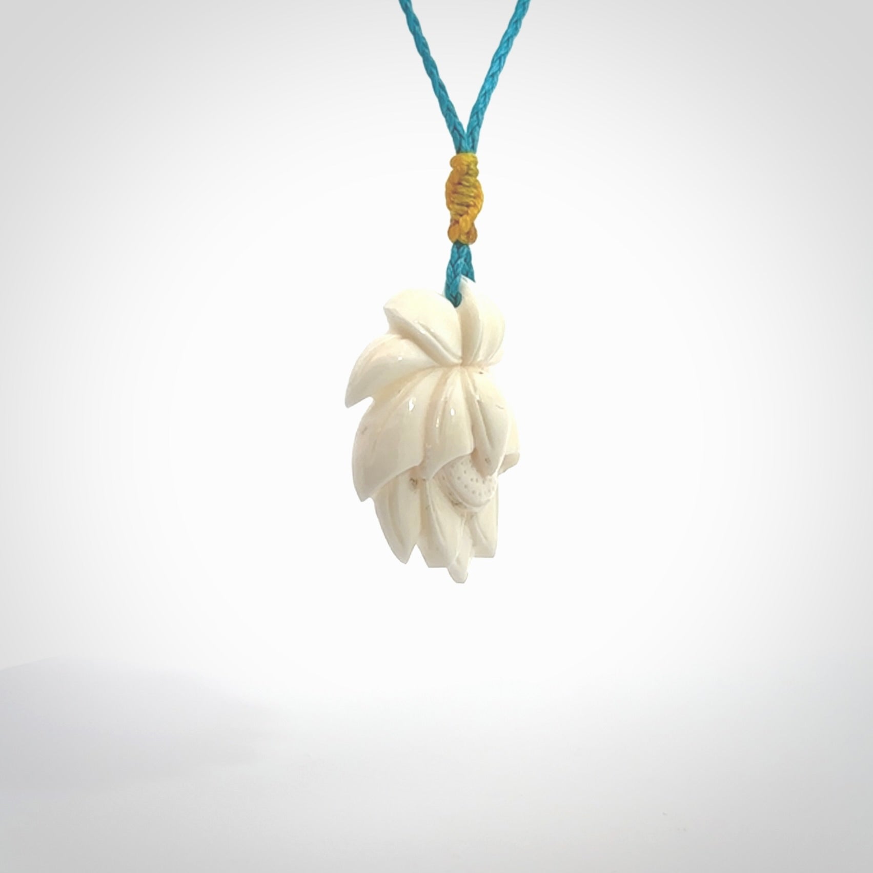 This is a hand carved lotus flower pendant. It is made from bone. This is a medium sized necklace and is a very unique pendant and is a wonderful necklace to wear. Hand carved bone lotus flower pendant with adjustable cord.