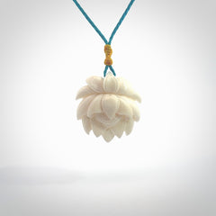 This is a hand carved lotus flower pendant. It is made from bone. This is a medium sized necklace and is a very unique pendant and is a wonderful necklace to wear. Hand carved bone lotus flower pendant with adjustable cord.