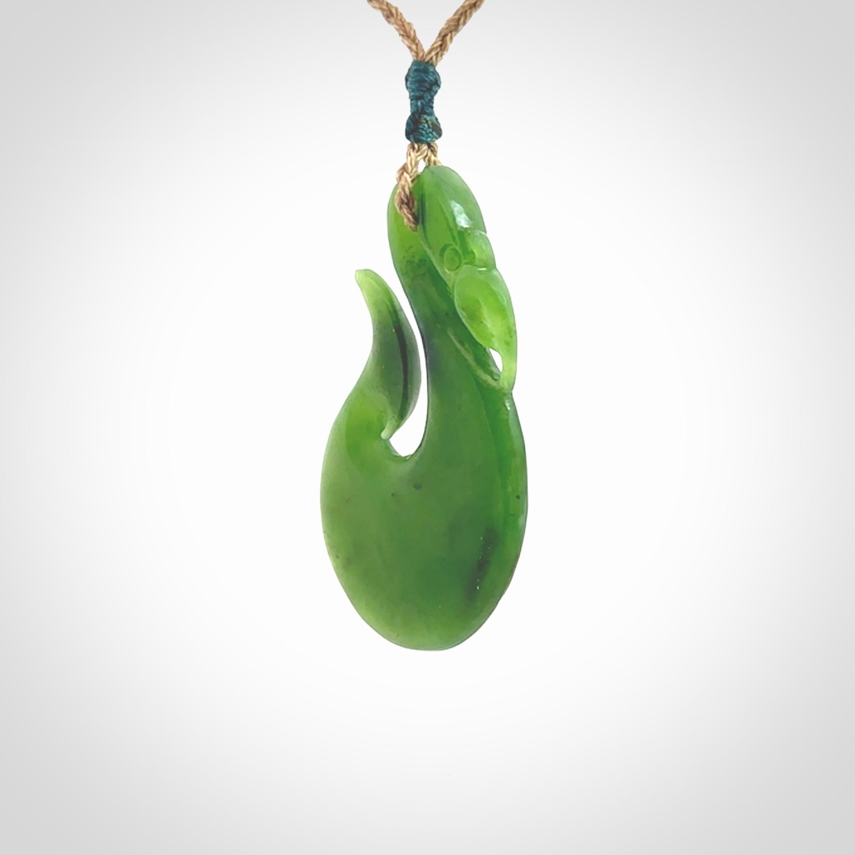 A New Zealand jade manaia necklace carved in lovely green New Zealand jade. The pendant is suspended from a plaited cord. The cord is length adjustable so you can position the pendant where it suits you best. One only Ross Crump Manaia with hook pendant.