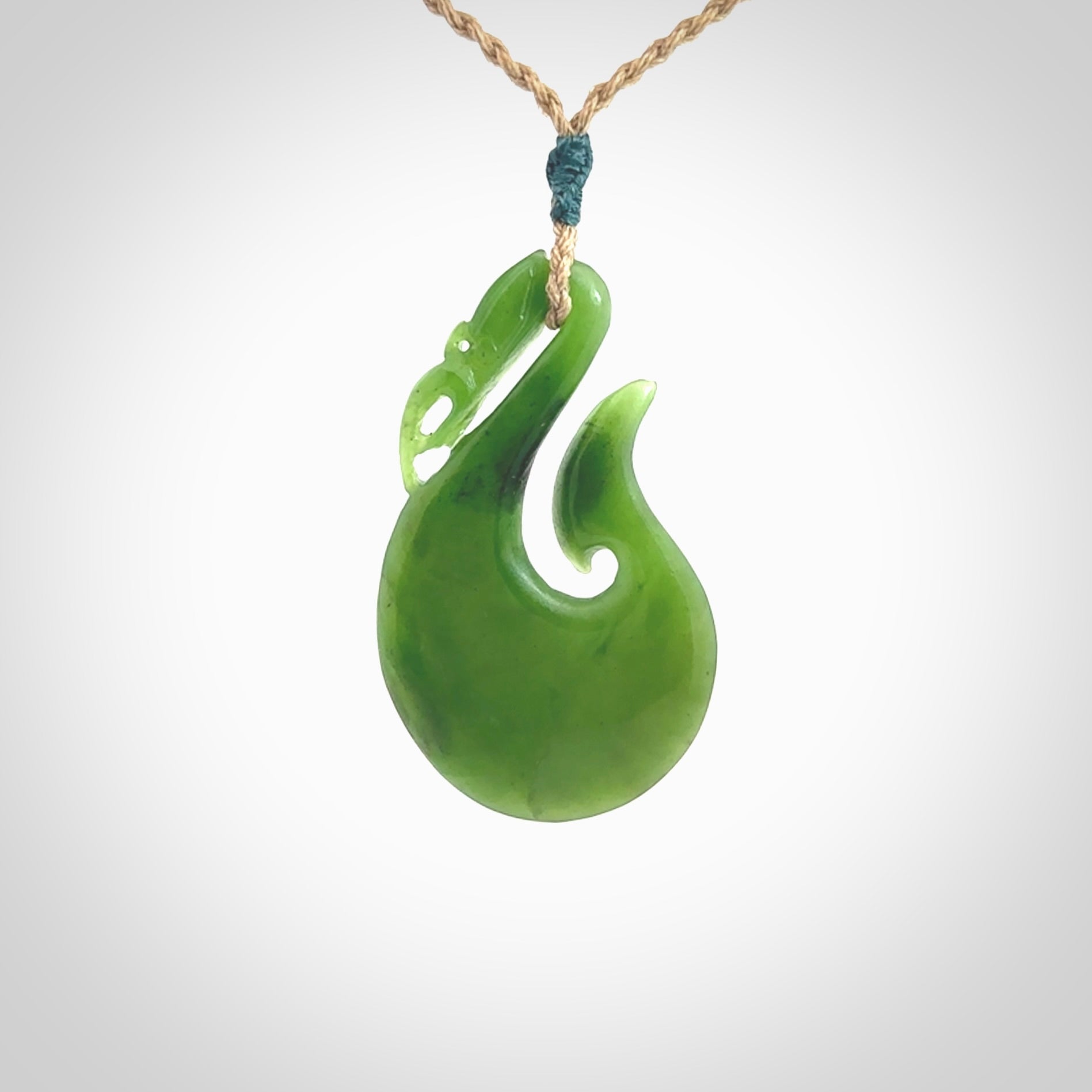 A New Zealand jade manaia necklace carved in lovely green New Zealand jade. The pendant is suspended from a plaited cord. The cord is length adjustable so you can position the pendant where it suits you best. One only Ross Crump Manaia with hook pendant.