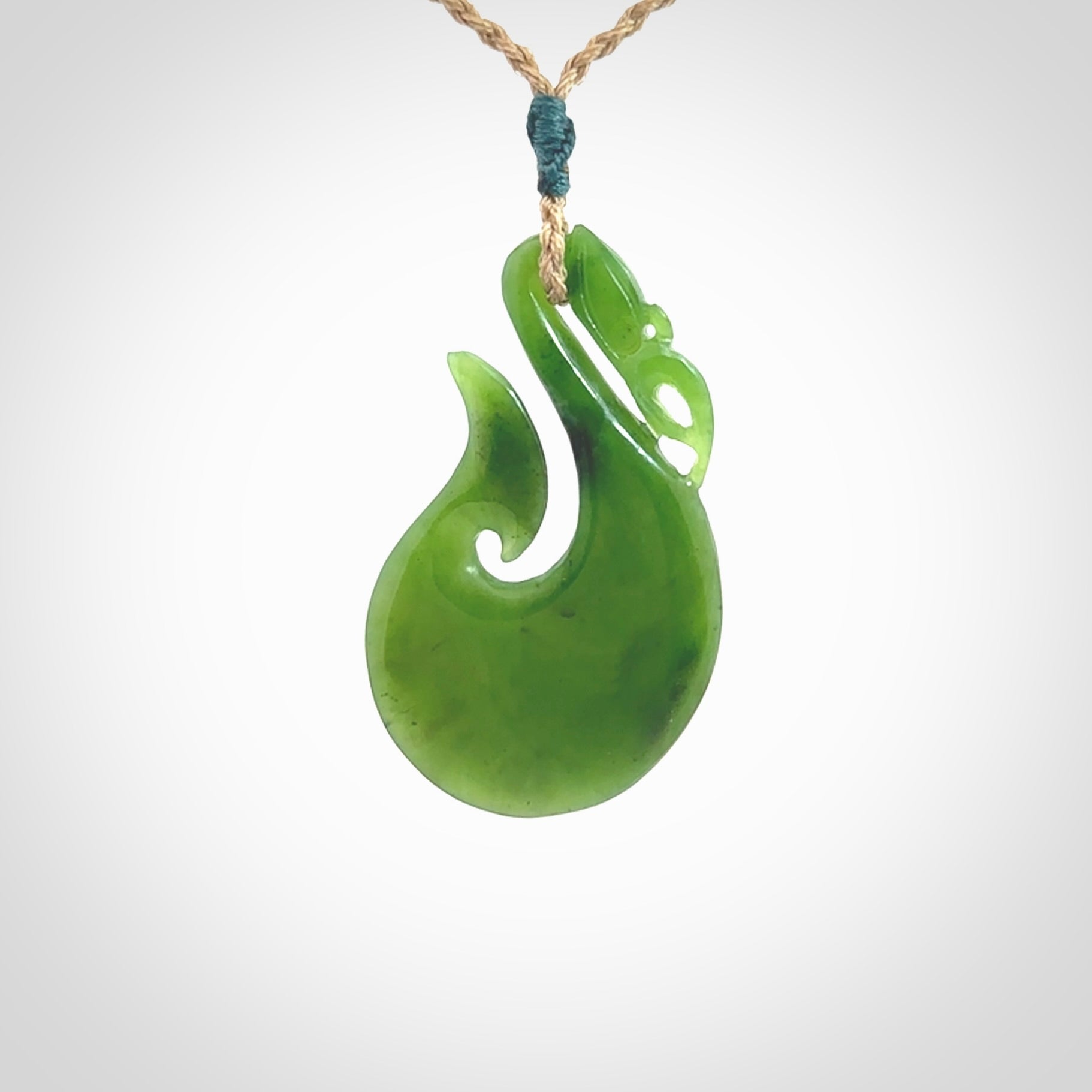 A New Zealand jade manaia necklace carved in lovely green New Zealand jade. The pendant is suspended from a plaited cord. The cord is length adjustable so you can position the pendant where it suits you best. One only Ross Crump Manaia with hook pendant.