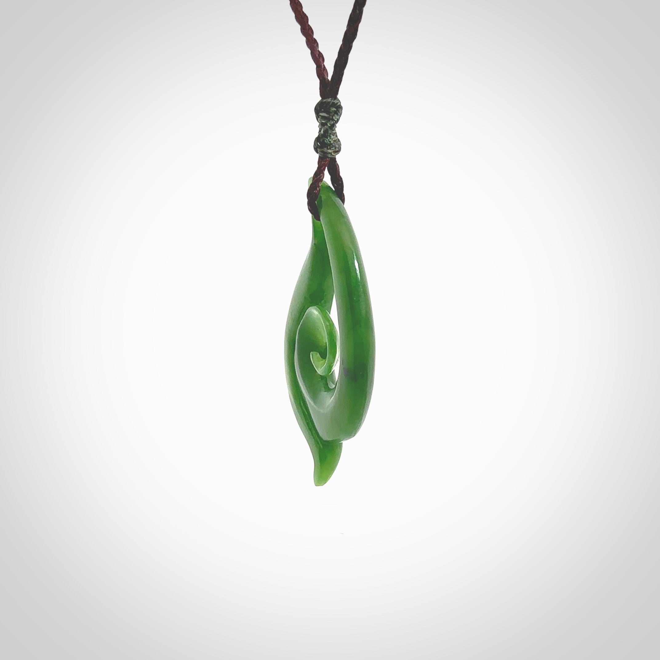 This pendant is a contemporary, medium sized and beautiful koru necklace carved from New Zealand Kawakawa Jade. Ross Crump carved this piece for us so the workmanship is outstanding. Handmade in New Zealand, a beautiful piece of jade jewellery.