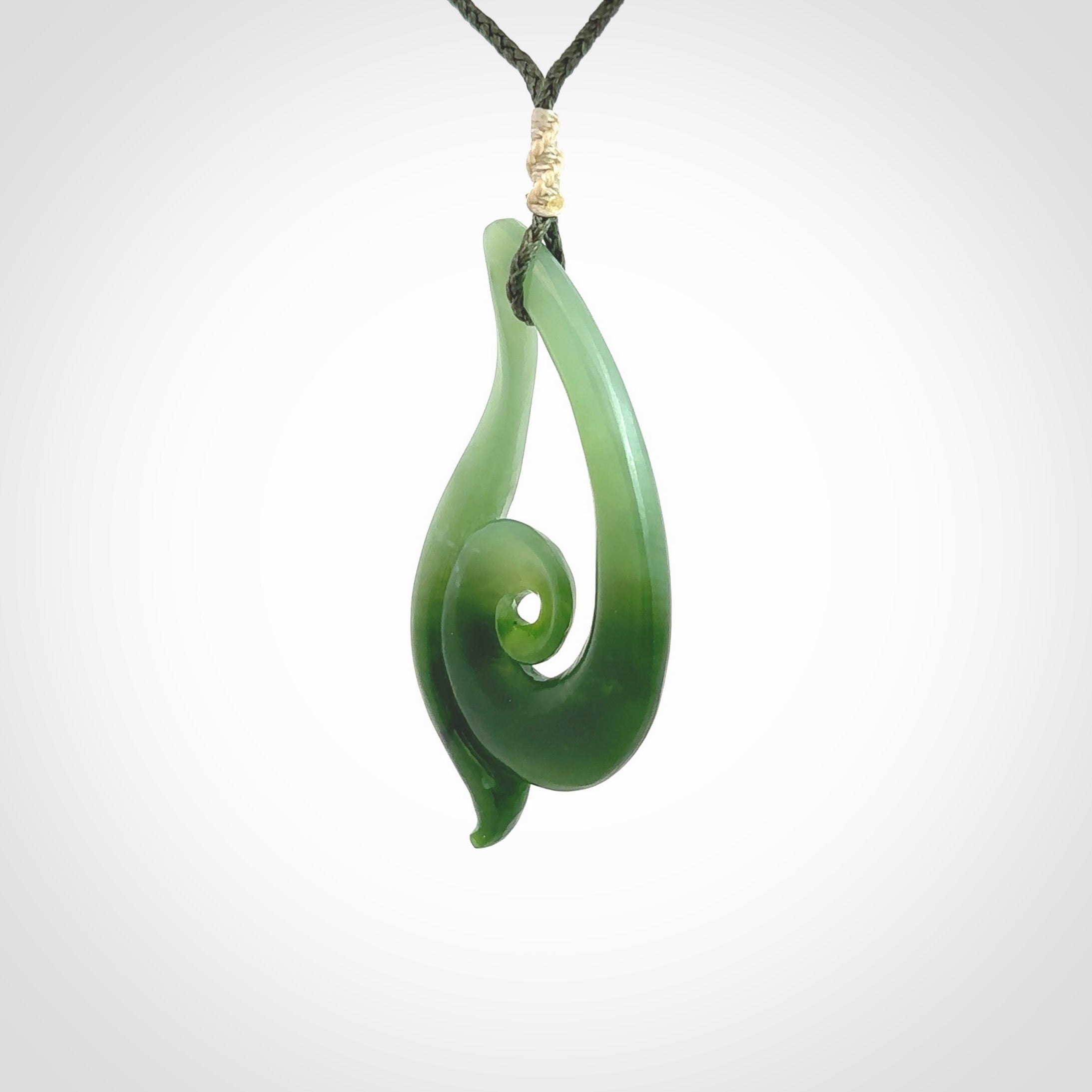 This pendant is a contemporary, large sized and beautiful koru drop necklace carved from New Zealand Inanga Jade. Ross Crump carved this piece for us so the workmanship is outstanding. Handmade in New Zealand, a beautiful piece of jade jewellery.