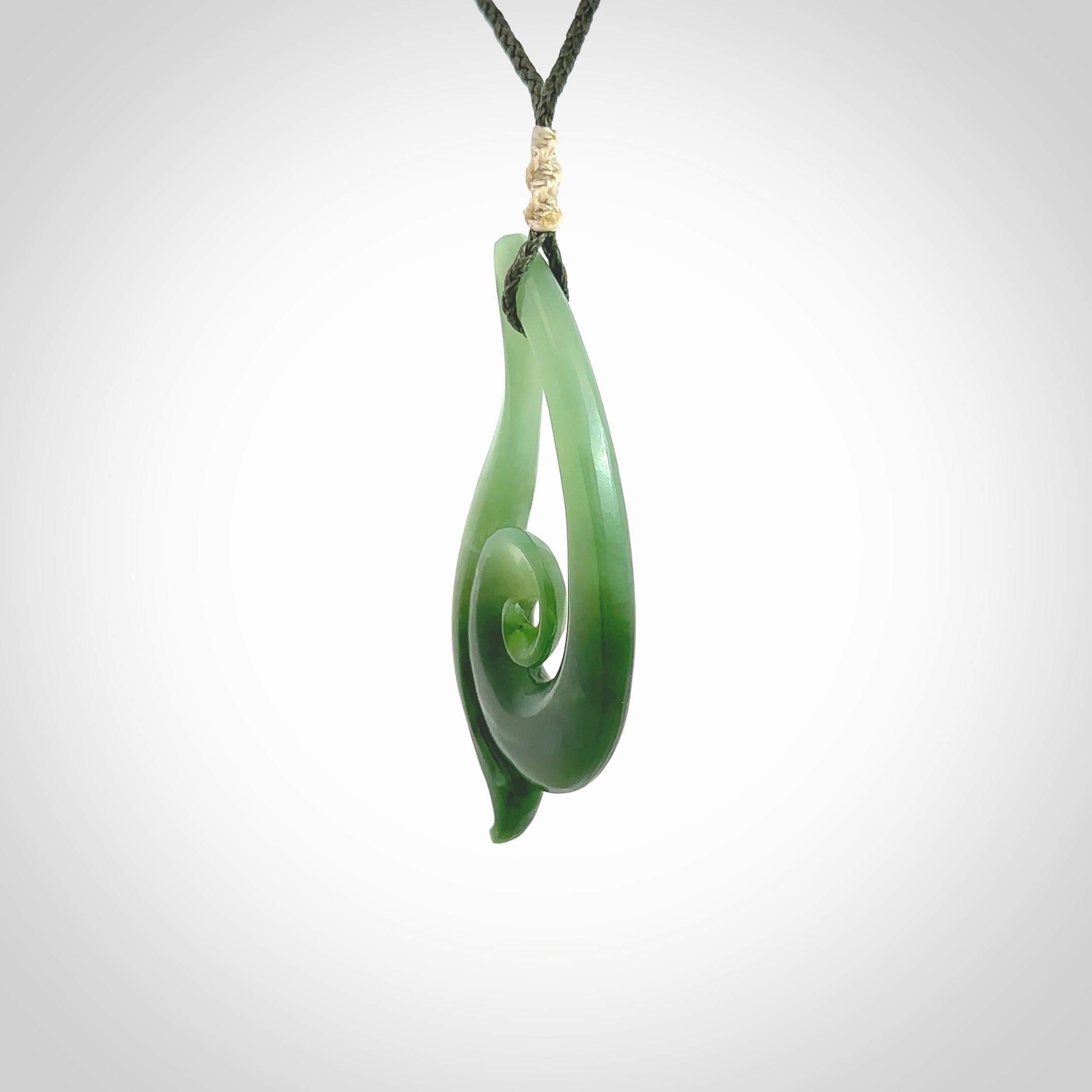 This pendant is a contemporary, large sized and beautiful koru drop necklace carved from New Zealand Inanga Jade. Ross Crump carved this piece for us so the workmanship is outstanding. Handmade in New Zealand, a beautiful piece of jade jewellery.