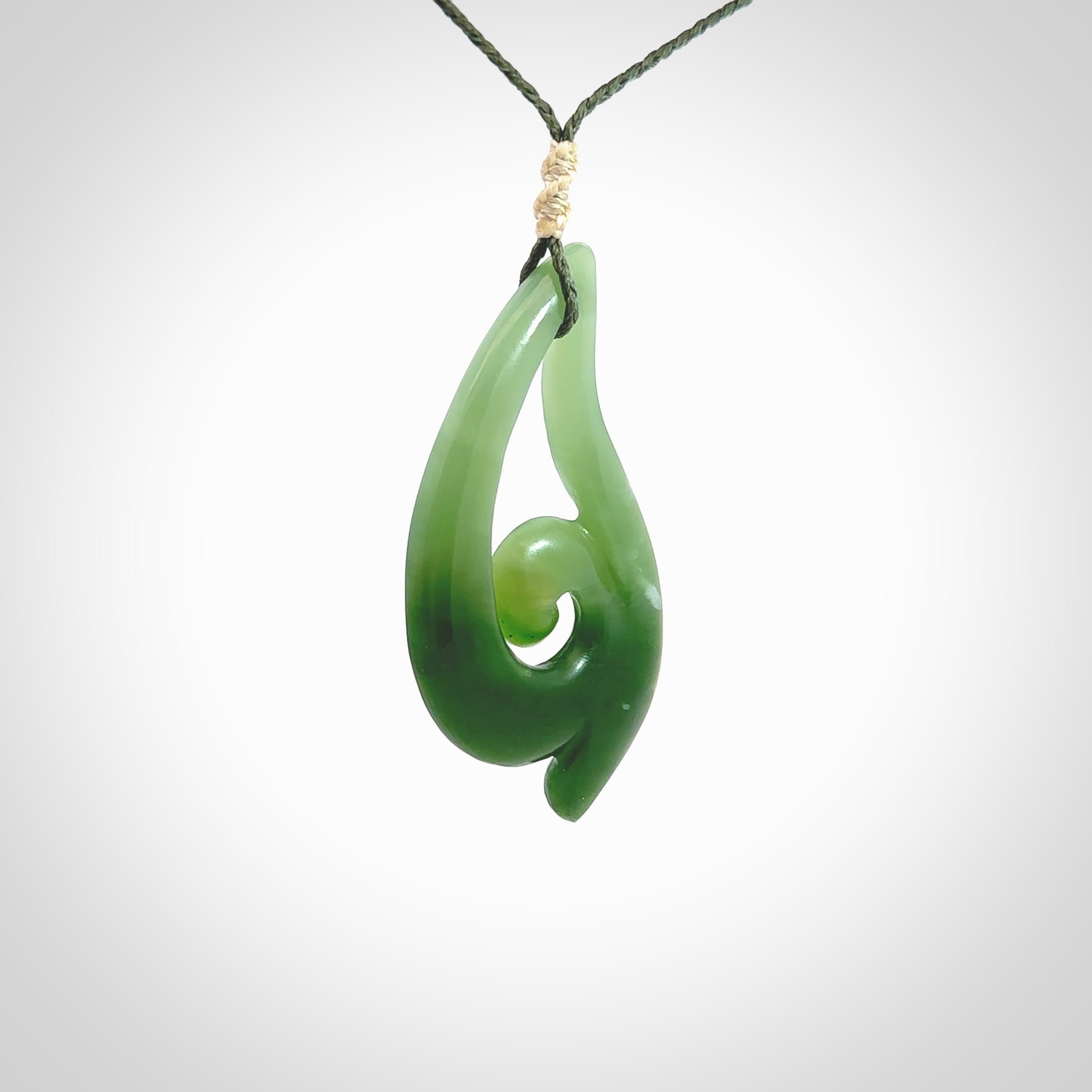 This pendant is a contemporary, large sized and beautiful koru drop necklace carved from New Zealand Inanga Jade. Ross Crump carved this piece for us so the workmanship is outstanding. Handmade in New Zealand, a beautiful piece of jade jewellery.