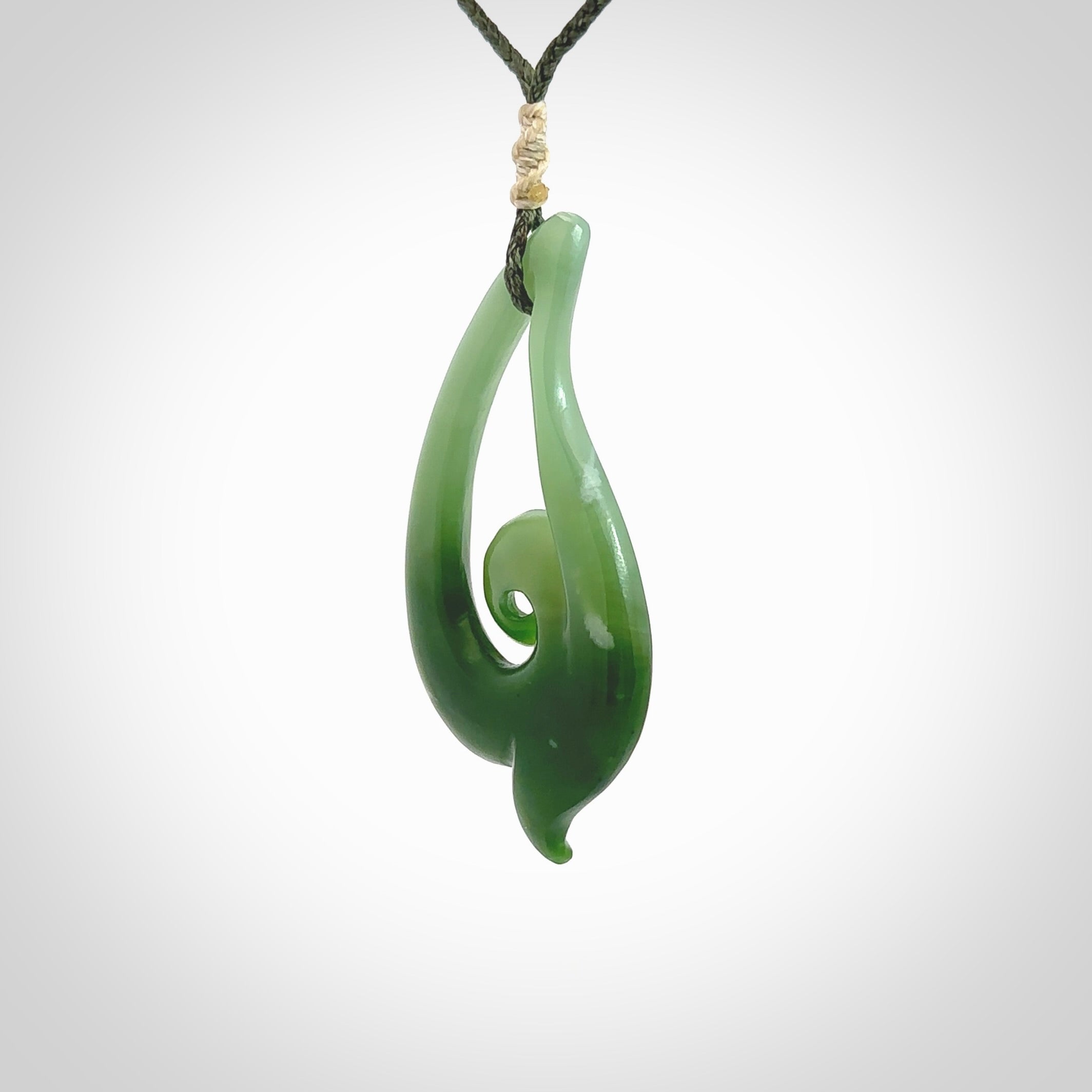 This pendant is a contemporary, large sized and beautiful koru drop necklace carved from New Zealand Inanga Jade. Ross Crump carved this piece for us so the workmanship is outstanding. Handmade in New Zealand, a beautiful piece of jade jewellery.