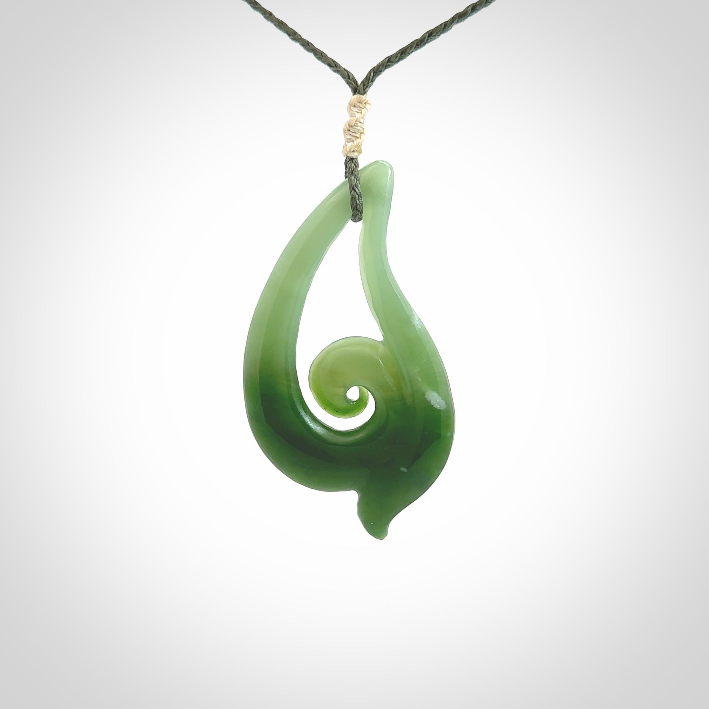 This pendant is a contemporary, large sized and beautiful koru drop necklace carved from New Zealand Inanga Jade. Ross Crump carved this piece for us so the workmanship is outstanding. Handmade in New Zealand, a beautiful piece of jade jewellery.