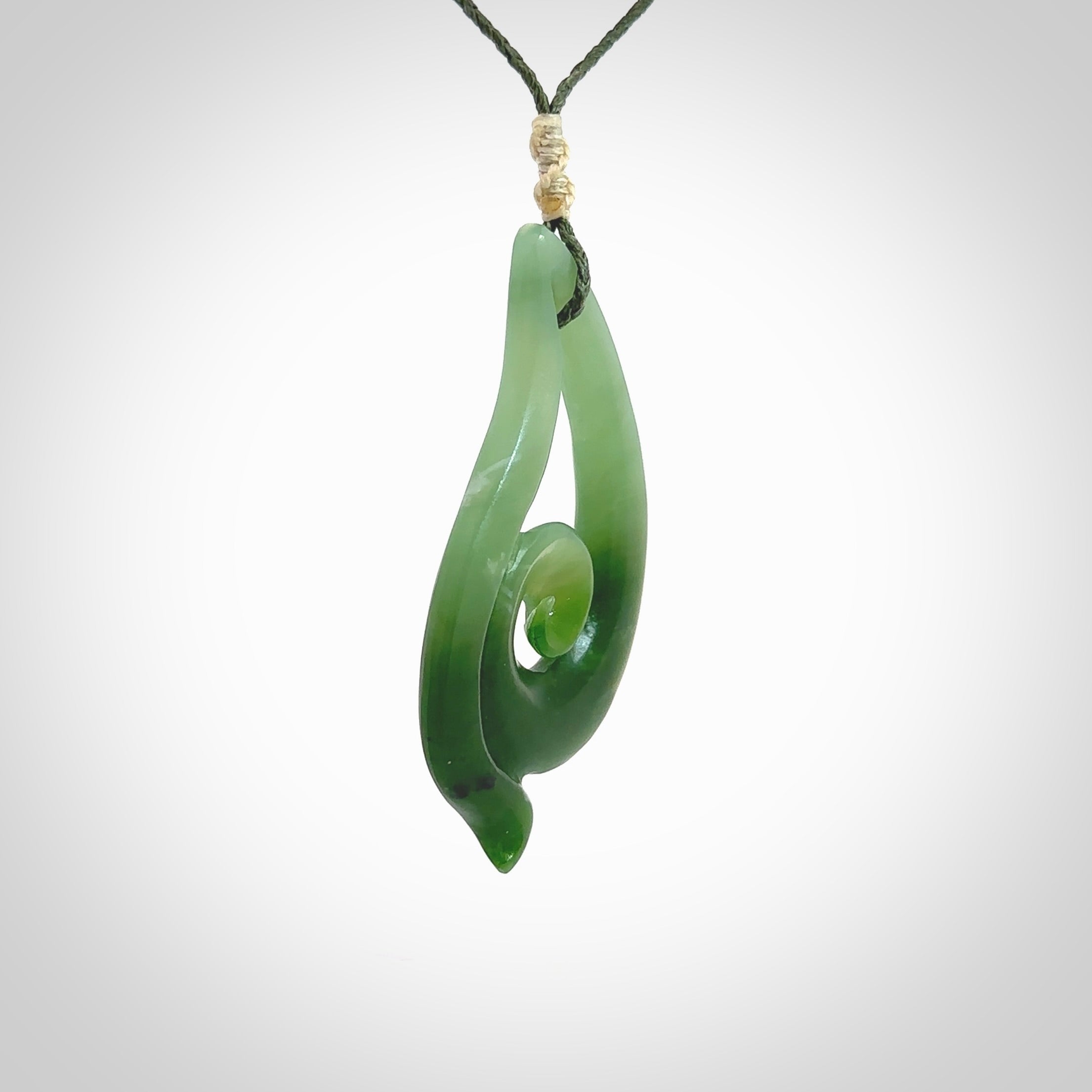 This pendant is a contemporary, large sized and beautiful koru drop necklace carved from New Zealand Inanga Jade. Ross Crump carved this piece for us so the workmanship is outstanding. Handmade in New Zealand, a beautiful piece of jade jewellery.