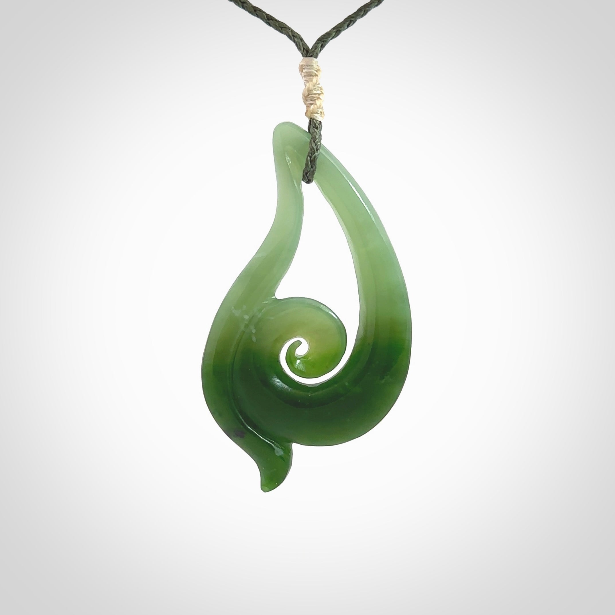 This pendant is a contemporary, large sized and beautiful koru drop necklace carved from New Zealand Inanga Jade. Ross Crump carved this piece for us so the workmanship is outstanding. Handmade in New Zealand, a beautiful piece of jade jewellery.