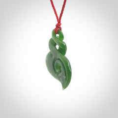 A beautiful carved double twist with koru pendant. This piece has been carved for us by Ross Crump and is a truly beautiful carving made from some of our finest and rarest jade. We will ship this to you with an express courier so you will have it quickly. A rare and beautiful work of wearable art from NZ Pacific.