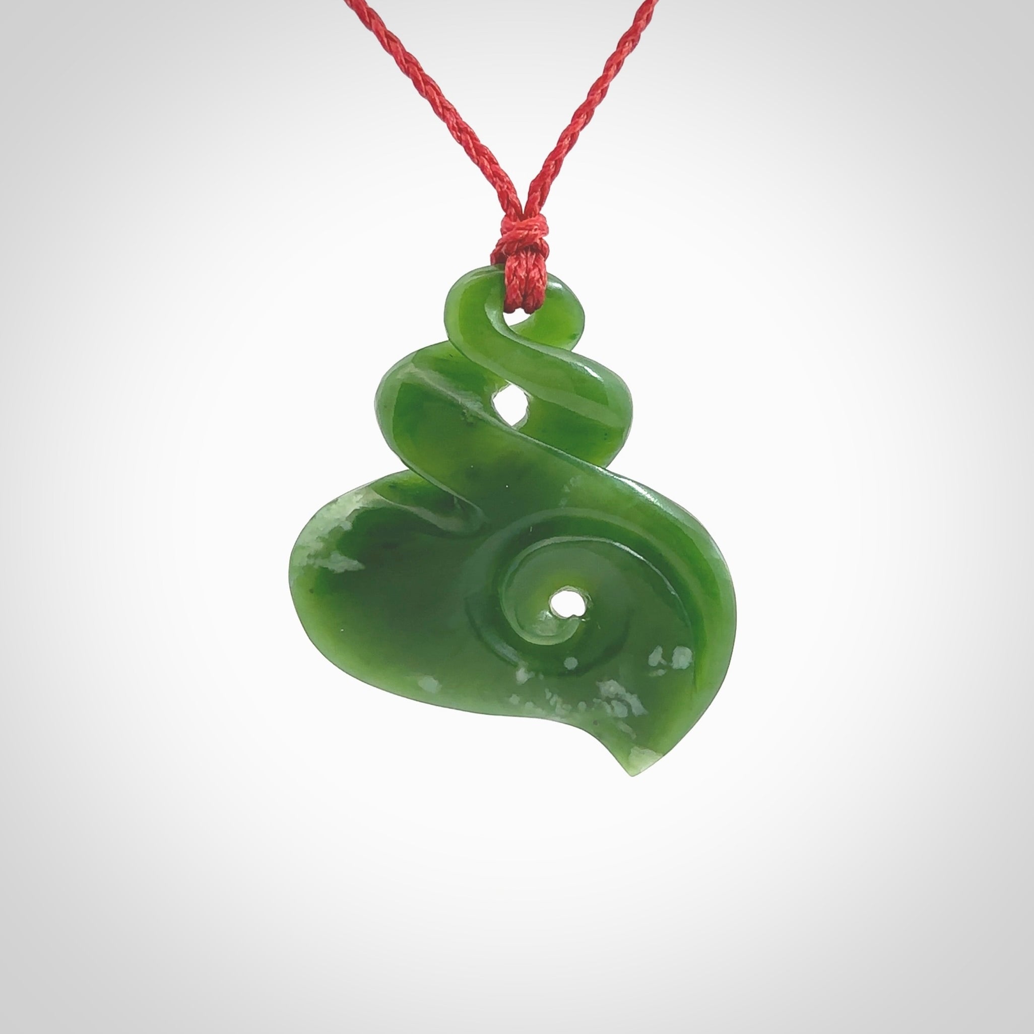 A beautiful carved double twist with koru pendant. This piece has been carved for us by Ross Crump and is a truly beautiful carving made from some of our finest and rarest jade. We will ship this to you with an express courier so you will have it quickly. A rare and beautiful work of wearable art from NZ Pacific.