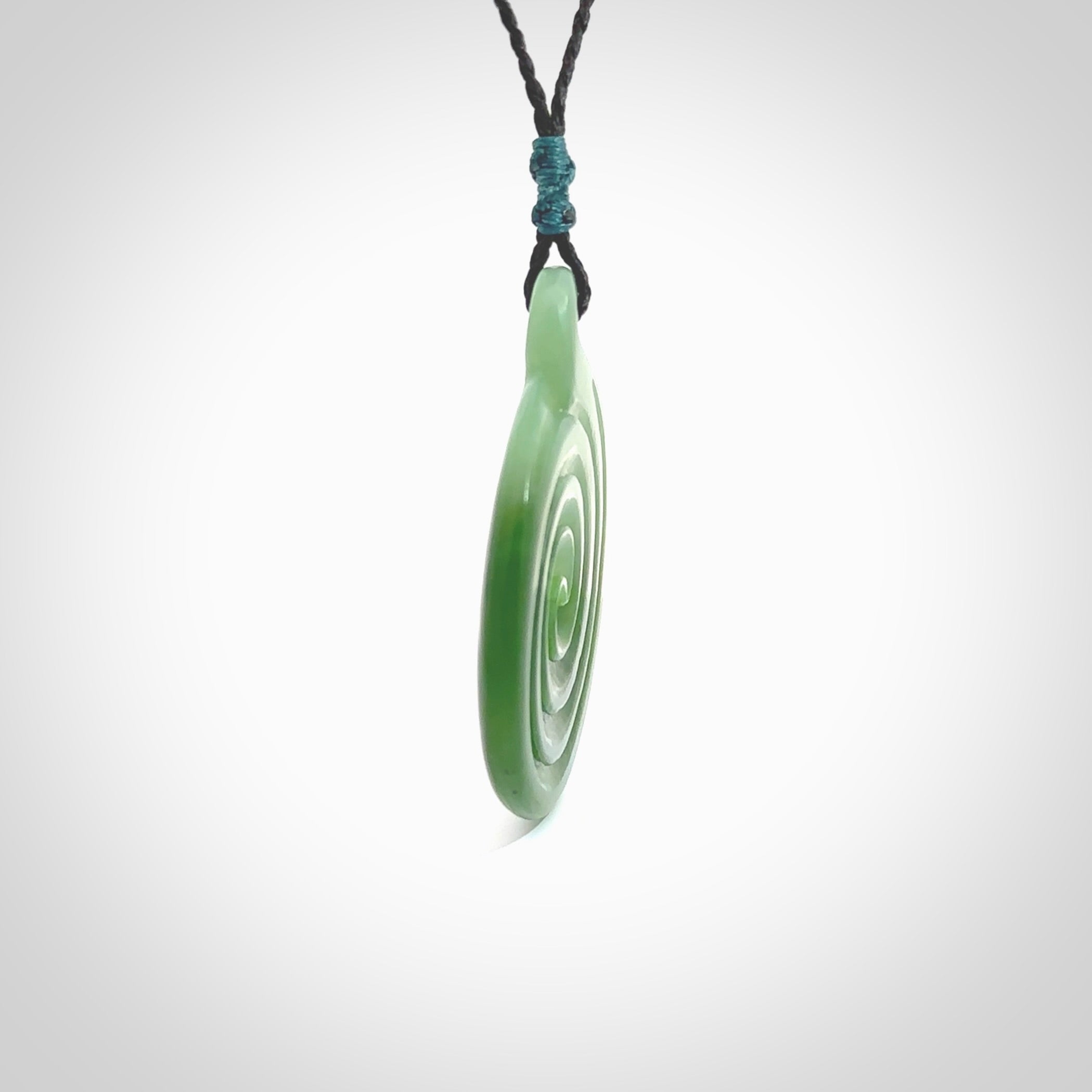 This pendant is a large sized and beautiful koru necklace carved from an semi-translucent light and dark green piece of New Zealand Kawakawa Jade. Ross Crump carved this piece for us so the workmanship is outstanding. Handmade in New Zealand, a beautiful piece of jade jewellery.