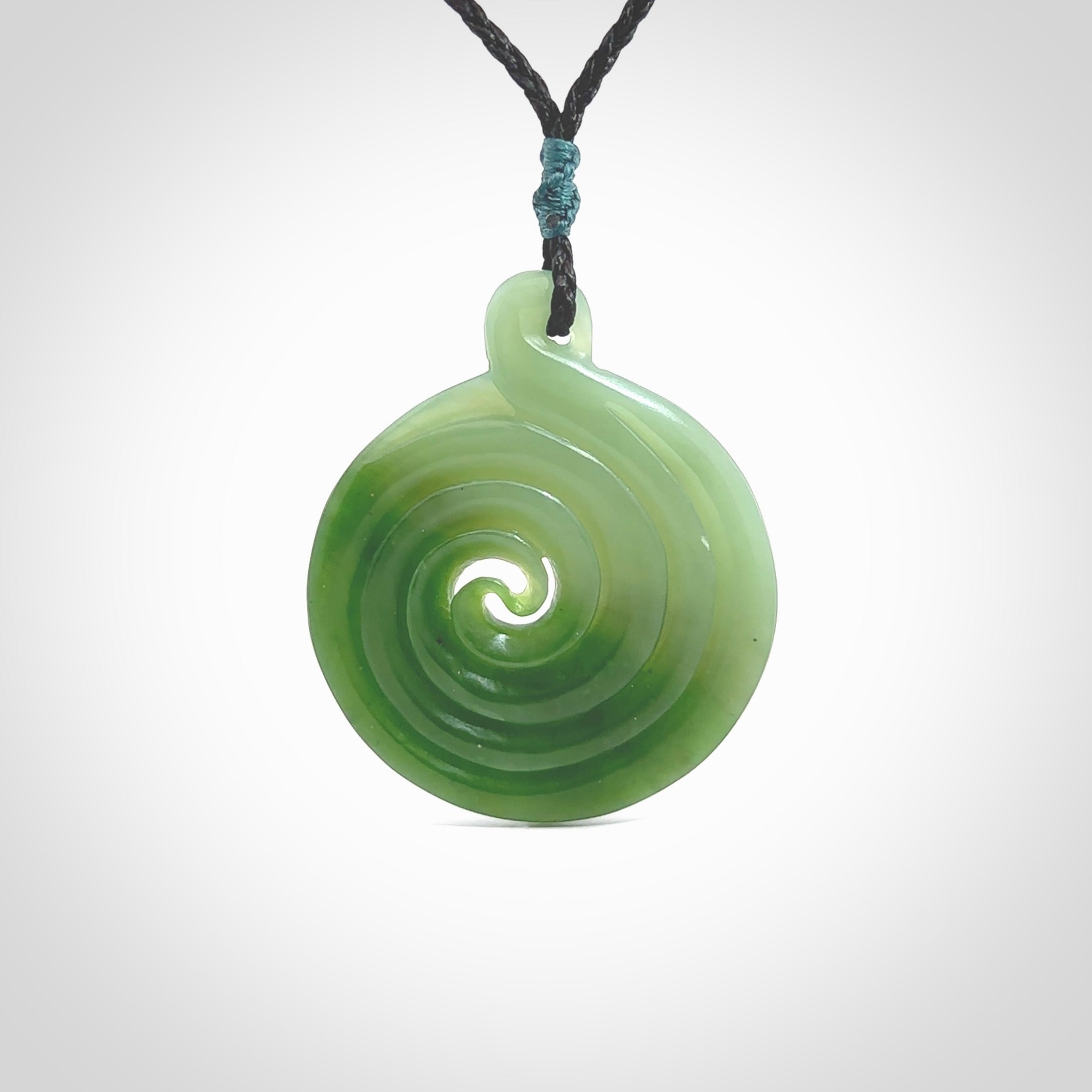 This pendant is a large sized and beautiful koru necklace carved from an semi-translucent light and dark green piece of New Zealand Kawakawa Jade. Ross Crump carved this piece for us so the workmanship is outstanding. Handmade in New Zealand, a beautiful piece of jade jewellery.