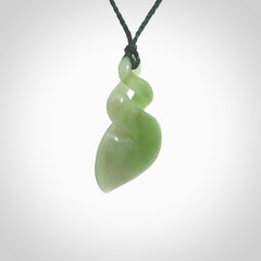 This piece is a fine, delicate drop shaped, double twist pendant. It was carved for us by Ross Crump from a lovely bright semi-translucent green piece of New Zealand Inanga jade. It is suspended on an manuka green coloured braided cord that is length adjustable.