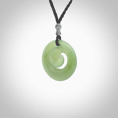 This picture shows a koru carving. A pendant carved from a lovely piece of New Zealand Inanga jade. We have suspended this necklace on a hand plaited cord in black and you can adjust its length so that you can position the pendant where it suits you best.