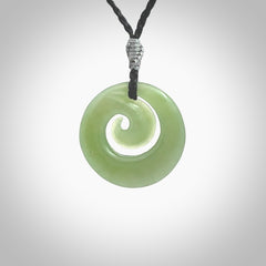 This picture shows a koru carving. A pendant carved from a lovely piece of New Zealand Inanga jade. We have suspended this necklace on a hand plaited cord in black and you can adjust its length so that you can position the pendant where it suits you best.