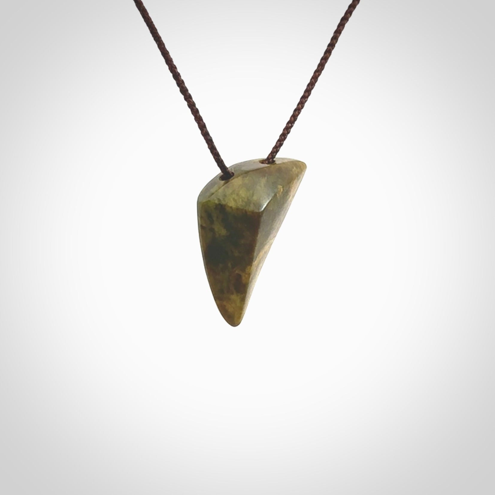 Hand carved pounamu drop pendant. Jade necklace hand made in New Zealand. A contemporary drop pendant carved from rare New Zealand flower jade. NZ Pacific jade jewellery for sale online. Provided with adjustable brown cord.