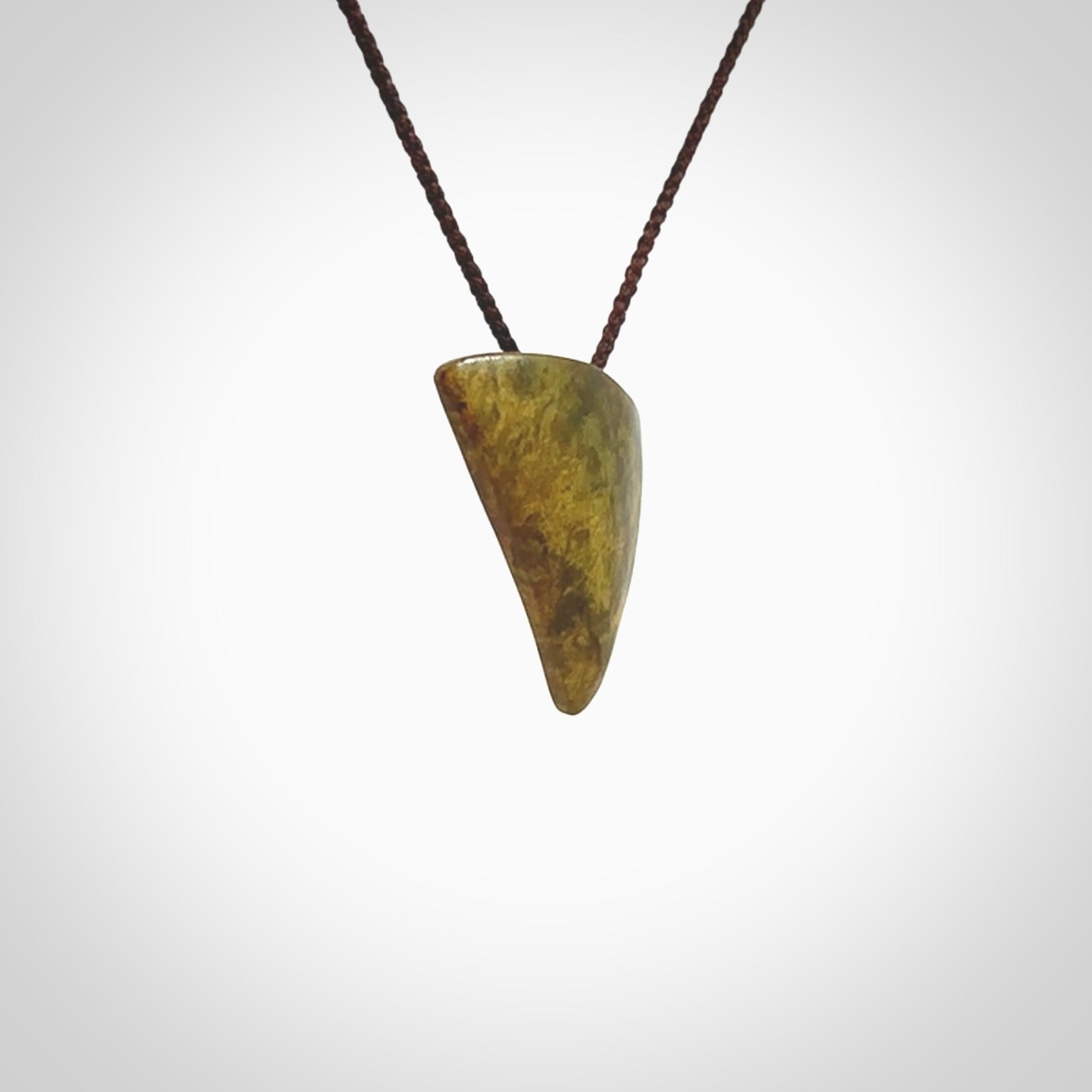 Hand carved pounamu drop pendant. Jade necklace hand made in New Zealand. A contemporary drop pendant carved from rare New Zealand flower jade. NZ Pacific jade jewellery for sale online. Provided with adjustable brown cord.