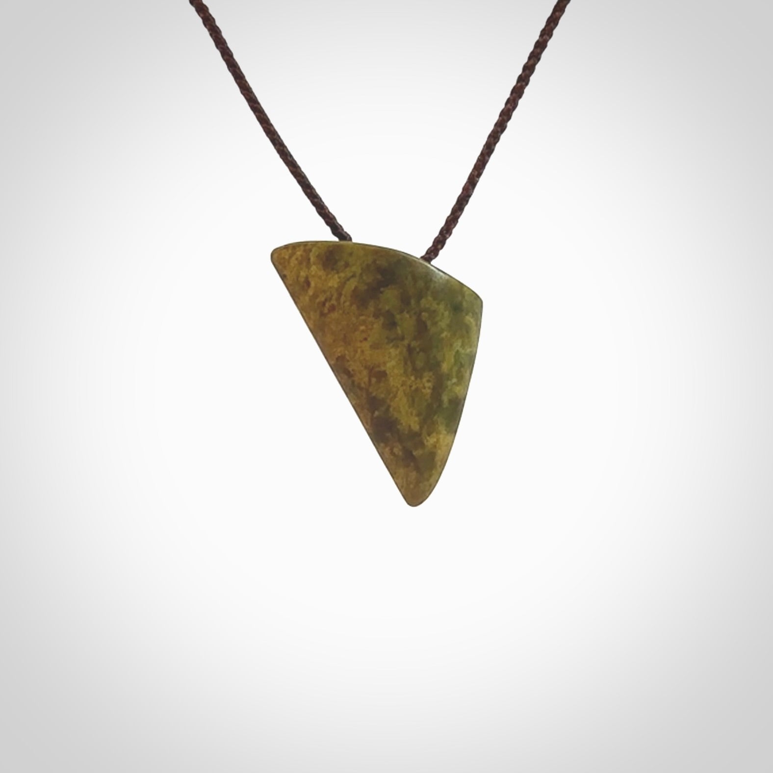 Hand carved pounamu drop pendant. Jade necklace hand made in New Zealand. A contemporary drop pendant carved from rare New Zealand flower jade. NZ Pacific jade jewellery for sale online. Provided with adjustable brown cord.