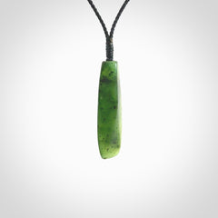 A lovely medium sized New Zealand Kawakawa jade drop pendant. This piece is made from a semi-translucent green jade with black specks and is a wonderful colour. Carved by Ric Moor for NZ Pacific and delivered worldwide. Provided with an adjustable black cord.