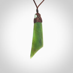 Hand carved Toki pendant from a lovely piece of local New Zealand Totoweka Jade. The quality of the workmanship and design is outstanding - this is a piece you will want to wear all the time. We have suspended this from a 4-plait brown cord which can be adjusted with a couple of slip knots and brown binding.