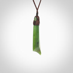 Hand carved Toki pendant from a lovely piece of local New Zealand Totoweka Jade. The quality of the workmanship and design is outstanding - this is a piece you will want to wear all the time. We have suspended this from a 4-plait brown cord which can be adjusted with a couple of slip knots and brown binding.