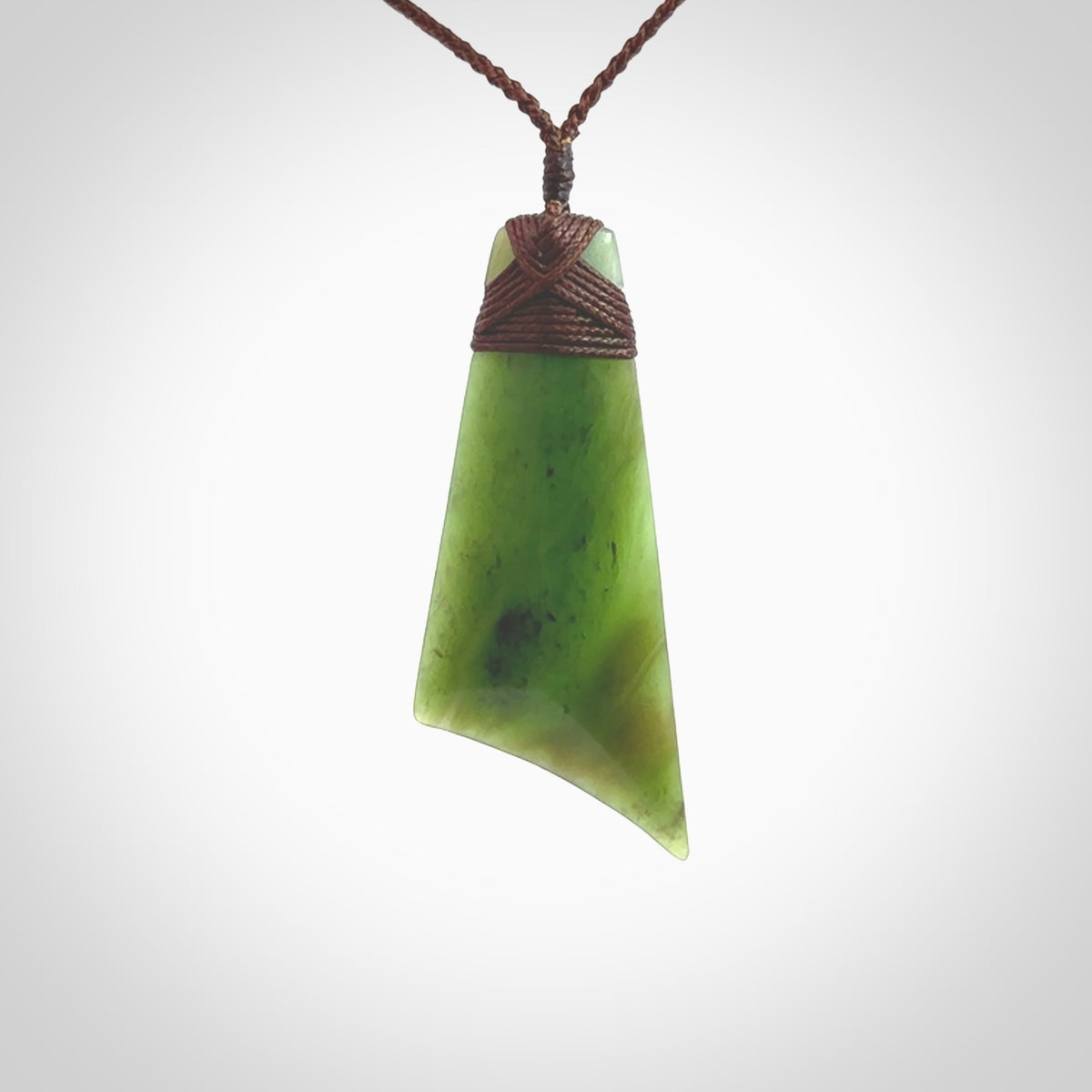 Hand carved Toki pendant from a lovely piece of local New Zealand Totoweka Jade. The quality of the workmanship and design is outstanding - this is a piece you will want to wear all the time. We have suspended this from a 4-plait brown cord which can be adjusted with a couple of slip knots and brown binding.